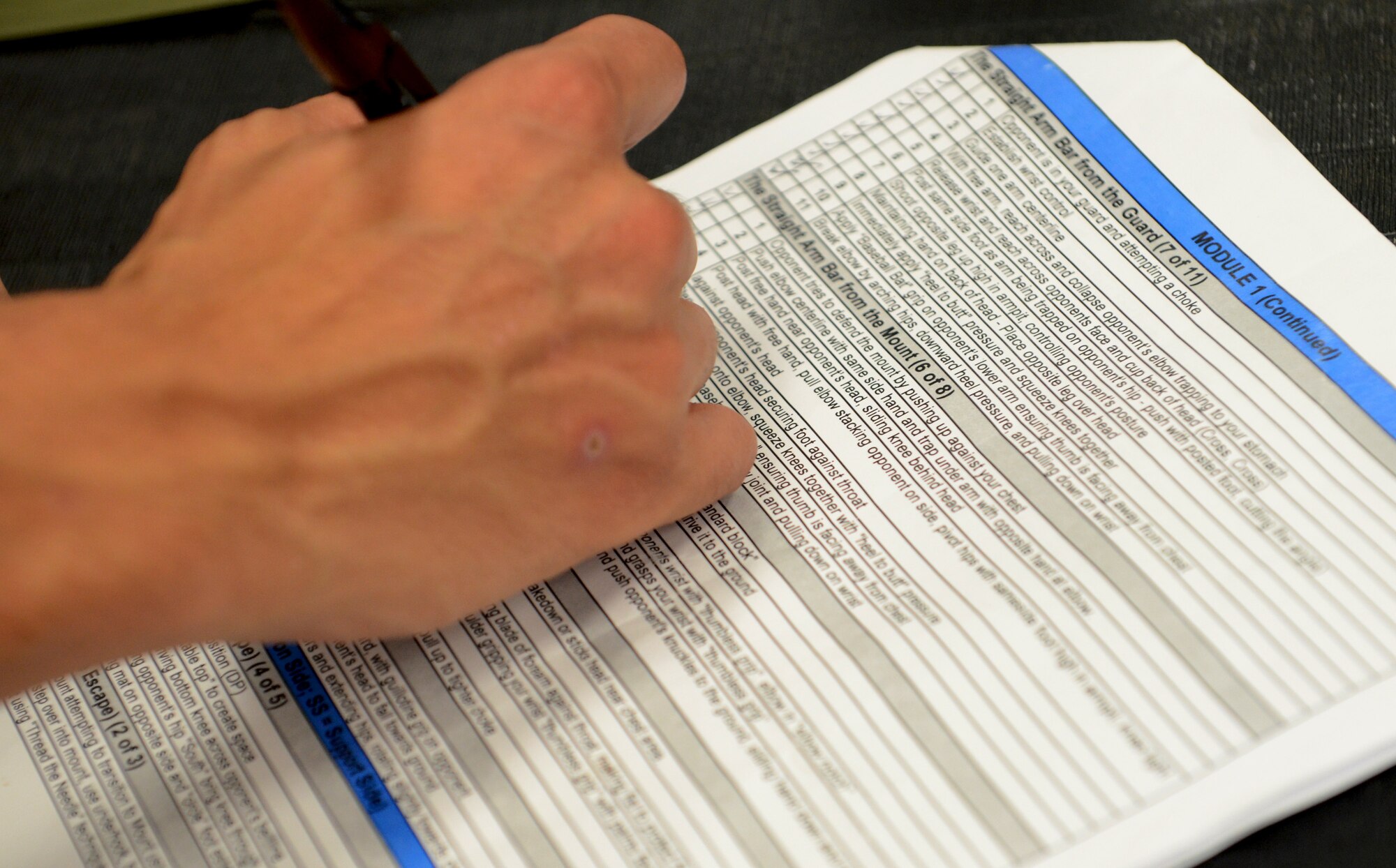 FORT JUAN MUNA, Guam—An instructor marks an evaluation sheet during the Air Force combative course, Aug. 30. The course was broken into two modules; the first module consists of proper stand-and strike techniques, while the second module consists of grappling techniques. (U.S. Air Force photo by Senior Airman Benjamin Wiseman/Released)