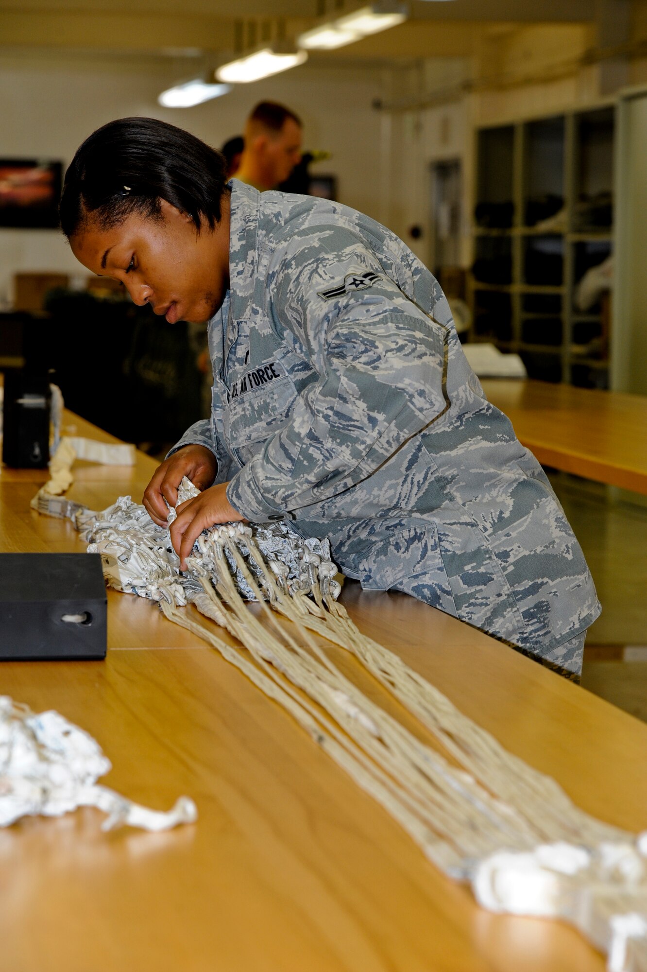 U.S. Air Force Airman 1st Class Christina Leonard, 18th Operations Support Squadron aircrew flight equipment apprentice, begins to pack an Advanced Concept Ejection Seat II Ejection Seat Stabilizing Drouge Parachute on Kadena Air Base, Japan, Sept. 5, 2012. The parachute system is deployed during moderate and high speed ejections. The Drogue parachute system deploys immediately after the seat leaves the rail, approximately 0.16 seconds during mode two and three escape sequences. (U.S. Air Force photo/Airman 1st Class Justin Veazie)