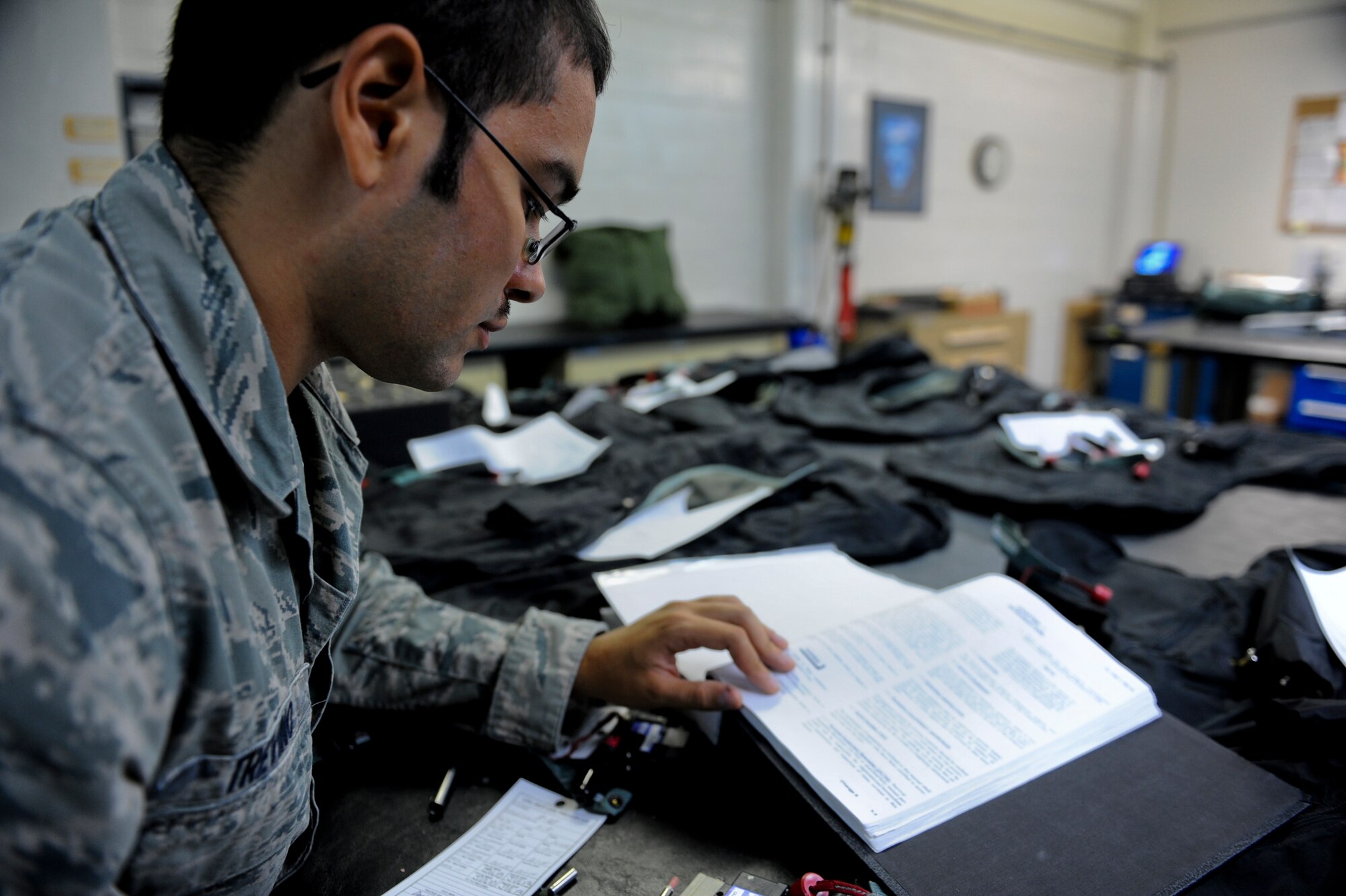U.S. Air Force Airman 1st Class Juan Trevino, 18th Operations Support Squadron aircrew flight equipment apprentice, references a low profile flotation collar technical order on Kadena Air Base, Japan, Sept. 5, 2012. The technical order is only for the flotation collar, a flotation device designed to support air crew stranded in water. (U.S. Air Force photo/Airman 1st Class Justin Veazie)