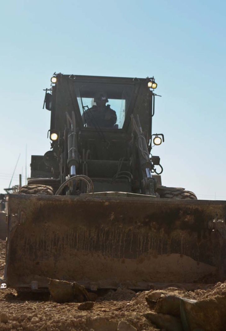 Corporal William Nikulos, a heavy equipment operator with 3rd Combat Engineer Battalion, piles rubble and tears down walls during a patrol base reduction operation, Feb. 23. Nikulos, a native of Caste Rock, W.S., and the rest of 3rd CEB worked the last 3 days to level half of the base. The battalion worked closely with the Afghan National Civil Order Police in deciding what to destroy and where to build new walls.