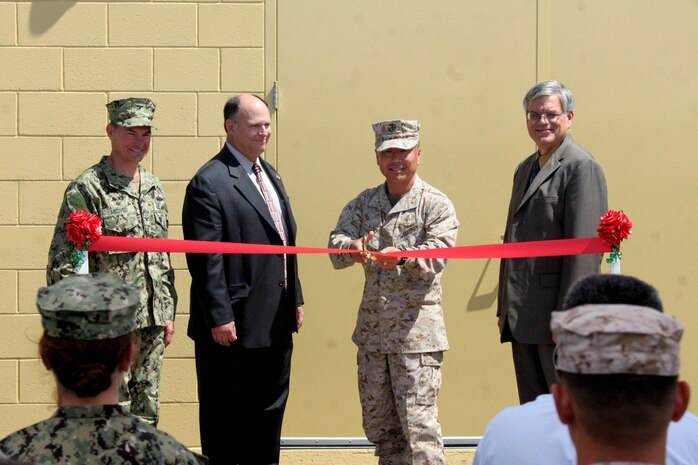 (From left to right) Capt. Marko Medved, officer in charge of construction, Marine Corps Installations West, Bob Riel, Vice President of Dynalectric Company, Brig. Gen. Daniel D. Yoo, commanding general, Marine Corps Recruit Depot San Diego and Western Recruiting Region and Dave Guebert, director of San Diego Gas and Electric, get ready to cut a ribbon at the PhotoVoltaic Ribbon Cutting Ceremony aboard MCRD Aug 29. The year-long project required Dynalectric to provide full engineering, procurement and tesing of a ground-based solar power facility with minimum power production. The 7.1 Mega Watts Solar Farm was constructed on an existing parking lot and was made of 4,224 high-efficiency crystalline panels and covers 154,000 square feet of the depot. It accounts of 13 percent of MCRD's electrical usage and is saving the depot more than $300,000 in electrical costs.