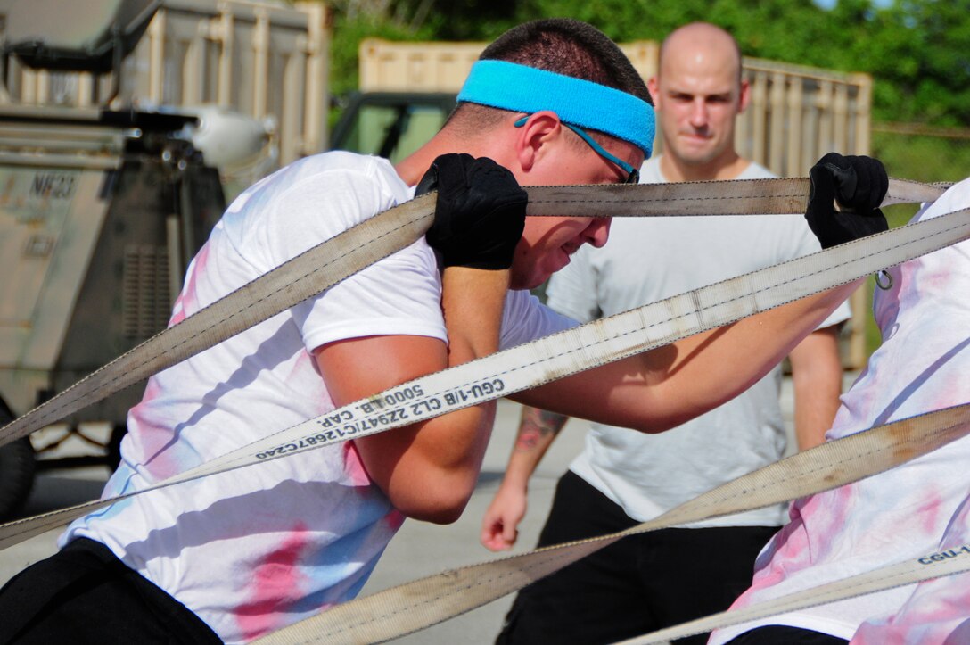 ANDERSEN AIR FORCE BASE, Guam -- Senior Airman Matthew McCoy, 36th Munitions Squadron conventional air launched cruise missile maintenance team member, works with his team to pull a tractor across a parking lot during the Ammo Olympics here, Aug. 30. The Ammo Olympics is an annual event where the Airmen of 36th Munitions Squadron build teams and compete with each other in events that test the Airmen’s strength, teamwork and ingenuity. (U.S. Air Force photo by Airman 1st Class Marianique Santos/Released)