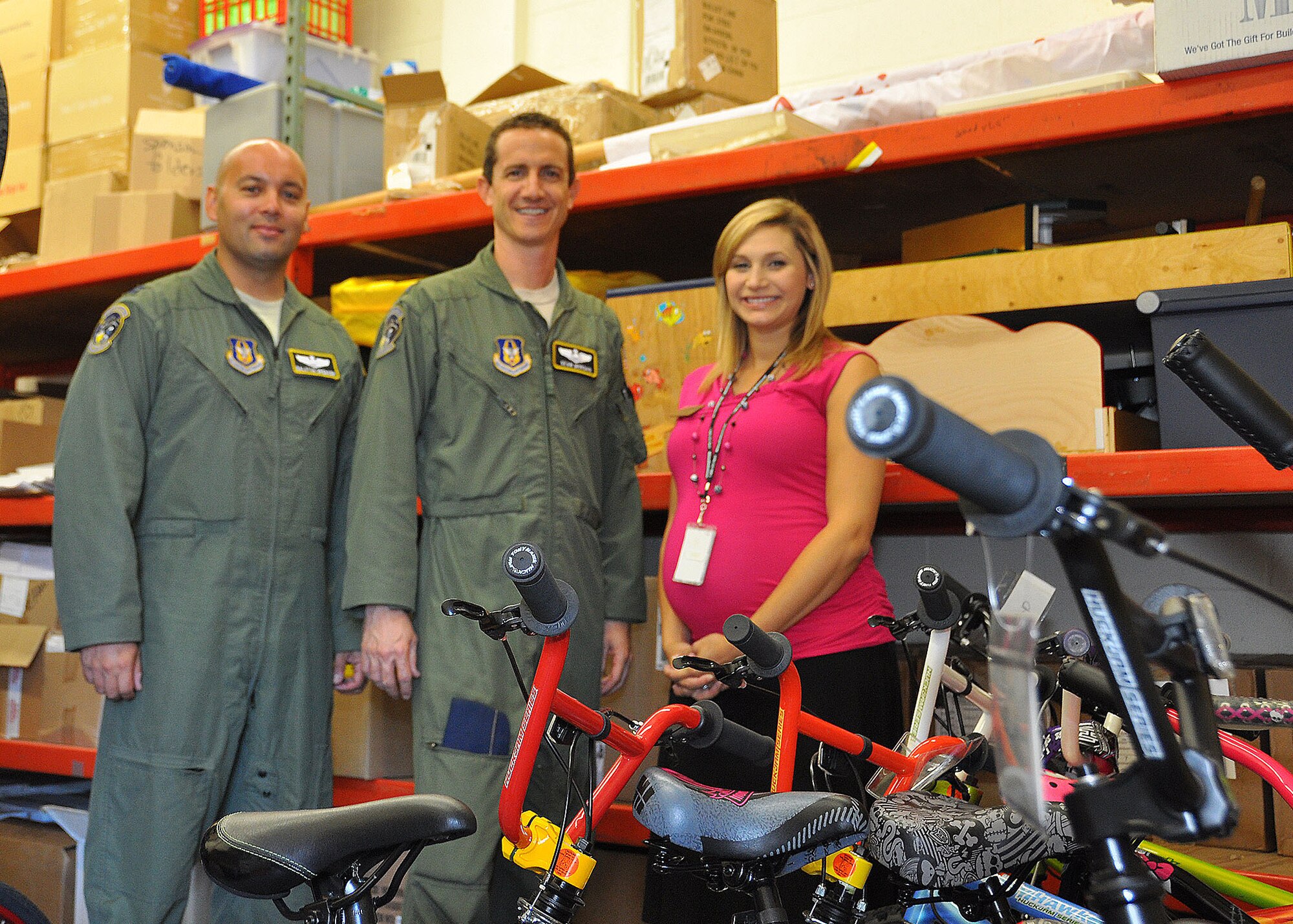 TRAVIS AIR FORCE BASE, Calif. -- Capt. Dalston Spencer, assistant chief of training and Lt.Col. Sean Morgan, assistant chief pilot, both assigned to the 70th ARS, and Victoria Byerly, 60th AMW Airman and Family Readiness Center relocation assistance coordinator, stand next to the remaining children's bicycles, part of a donation to the Travis Bike Barn from Dynacraft Inc. Seventy-five bicycles were originally donated by the company to the Travis Bike Barn at the A&FRC, to support Airmen and family members without other means of transportation. (U.S. Air Force photo/Senior Amn. Cindy Alejandrez)
