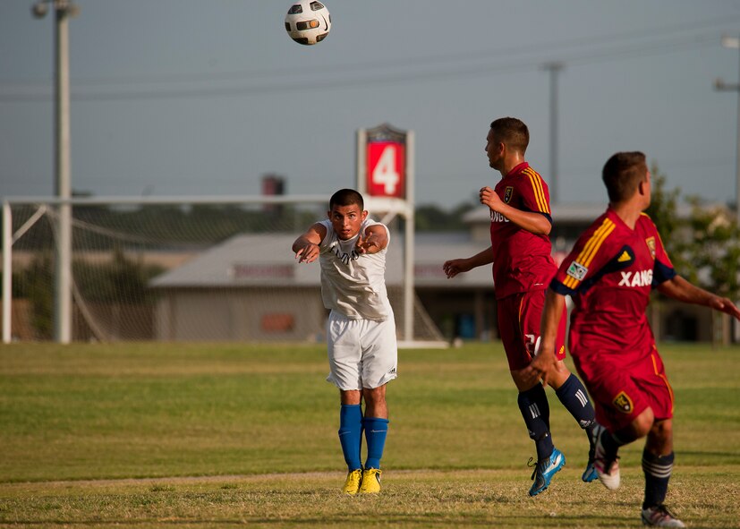 Dyess winger Alex Herrera throws in a ball over opponents from Team Hill Sept. 1, 2012, during the Defender’s Cup at San Antonio. During the first day of the tournament, teams were placed into groups of four and played each other to see where they would be placed in the tournament’s bracket. Team Dyess went undefeated during the group portion, beating Team Hill, Columbus and Medina. This placed them No. 1 in their group and fifth overall in the 22-team competition. Having the top seed in their group gave Dyess a first-round bye on the second day of the tournament, where they faced Luke AFB. In a tough game, Luke defeated Dyess in penalty kicks after tying 1-1 during regulation. (U.S. Air Force photo by Airman 1st Class Damon Kasberg/Released)