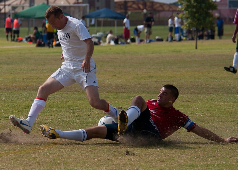 Dyess forward Branden Lane loses the ball after an opponent from Medina slide tackles him Sept. 1, 2012, during the Defender’s Cup at San Antonio. During the first day of the tournament, teams were placed into groups of four and played each other to see where they would be placed in the tournament’s bracket. Team Dyess went undefeated during the group portion, beating Team Hill, Columbus and Medina. This placed them No. 1 in their group and fifth overall in the 22-team competition. Having the top seed in their group gave Dyess a first-round bye on the second day of the tournament, where they faced Luke AFB. In a tough game, Luke defeated Dyess in penalty kicks after tying 1-1 during regulation. (U.S. Air Force photo by Airman 1st Class Damon Kasberg/Released)