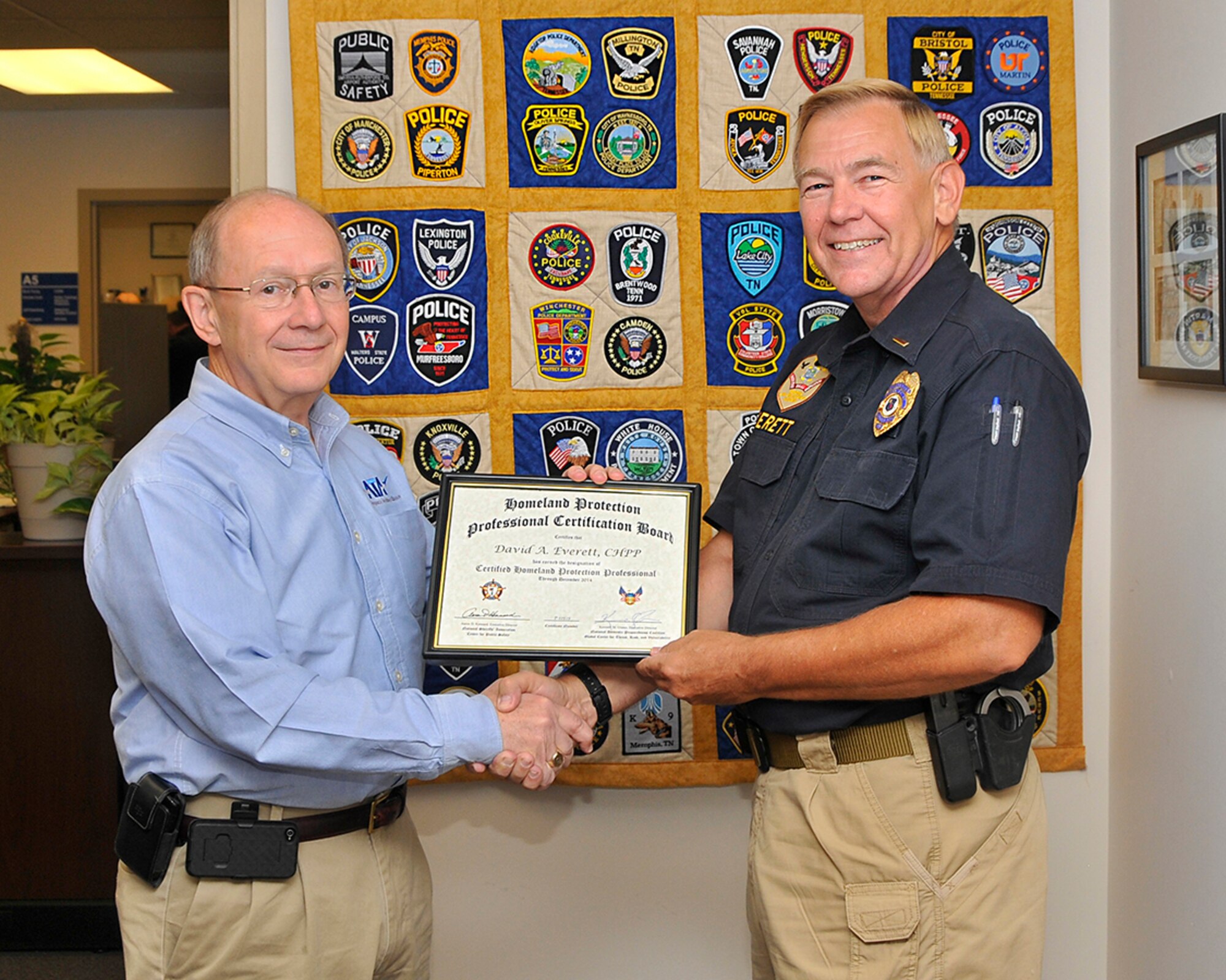 Pat Eagan (left), ATA Mission Support Department director, congratulates David Everett, a plans and programs officer with the Arnold Air Force Base police department, on his earning the designation of Certified Homeland Protection Professional (CHPP).