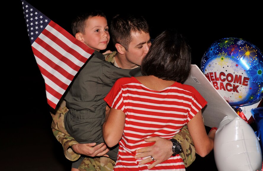 A service member greets his wife and son during Operation Homecoming at Cannon Air Force Base, N.M., Sept. 5, 2012. Operation Homecoming is a monthly event held to welcome Air Commandos back from worldwide deployments and reunite them with family and friends. (U.S. Air Force photo/Airman 1st Class Ericka Engblom)