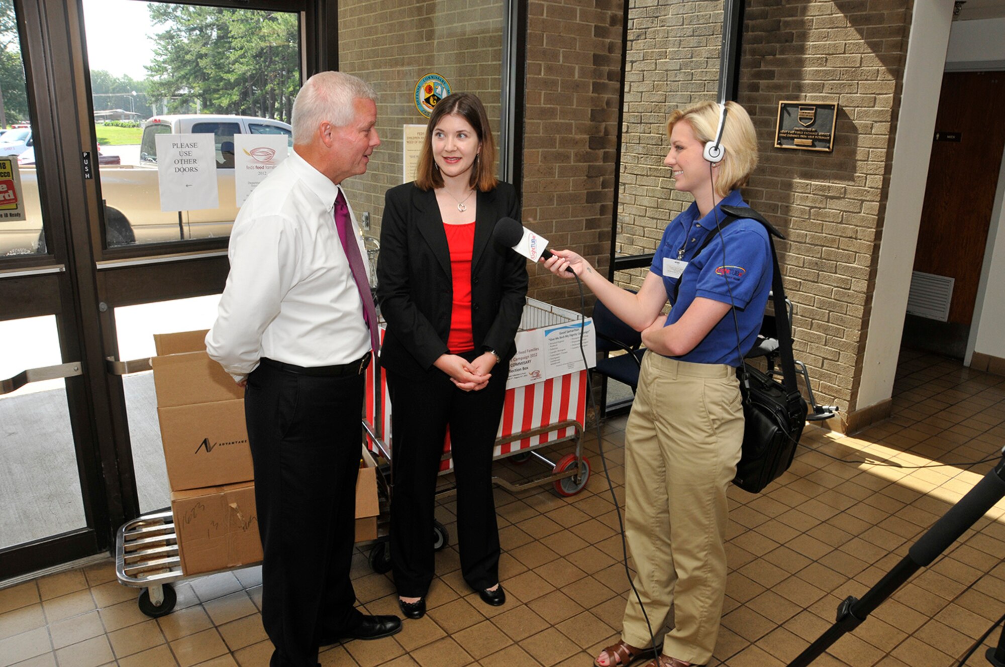 Tullahoma Good Samaritan Outreach Program volunteer Timothy White Keller answers questions from Tullahoma LightTUBe Channel 6 anchor Chelsea Adams (far right) about the Feds Feed Family (FFF) food drive initiated by Arnold Engineering Development Complex’s (AEDC) Junior Force Council. Patty Stiggins (center) is AEDC’s Junior Force Council FFF food drive coordinator for 2012. (Photo by Rick Goodfriend)