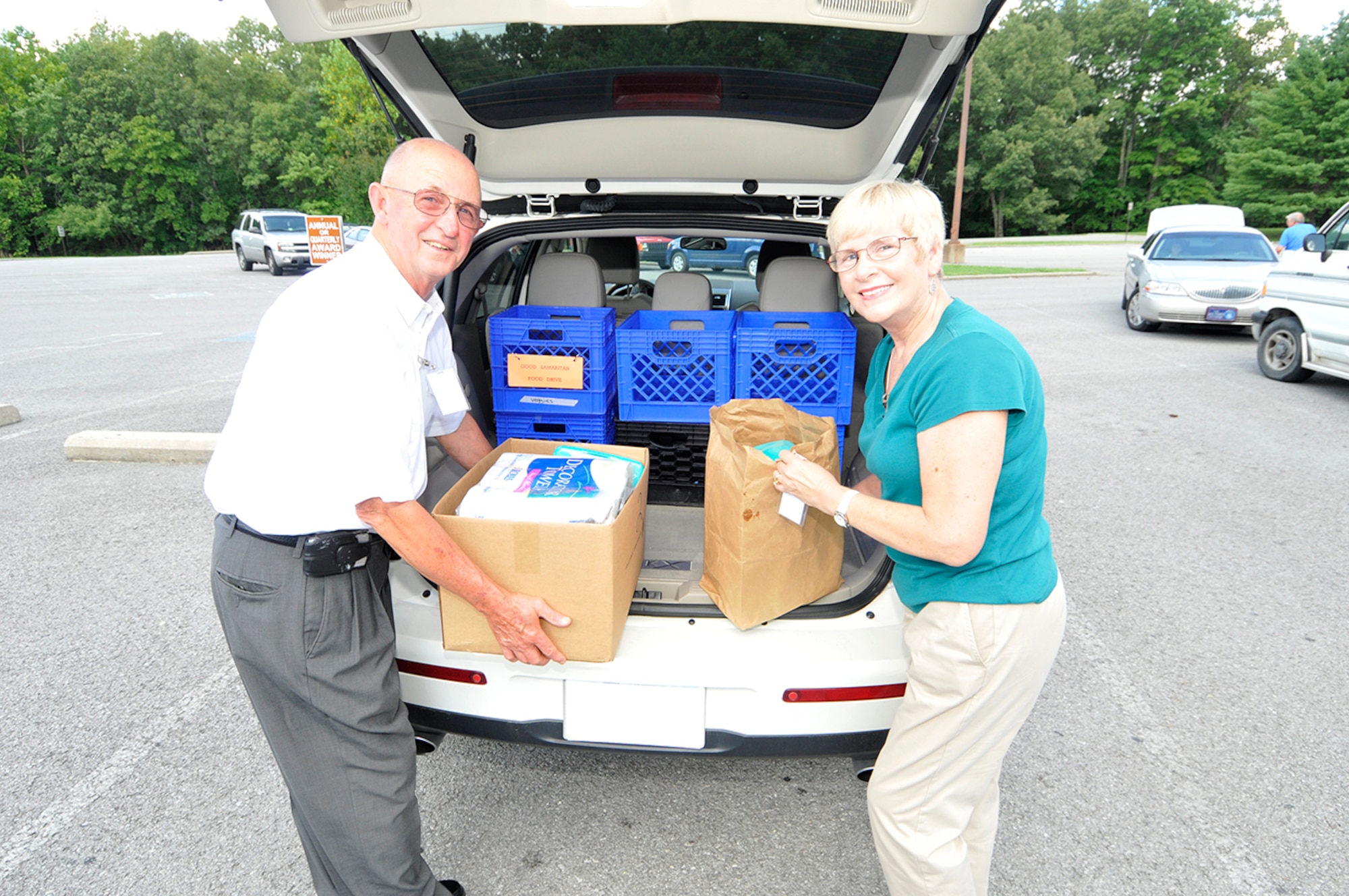 Decherd Good Samaritan volunteers Roy and Lynne Shoeneman load non-perishable food and hygiene items collected by Junior Force Council members into a car in AEDC’s commissary parking lot. (Photo by Rick Goodfriend)
