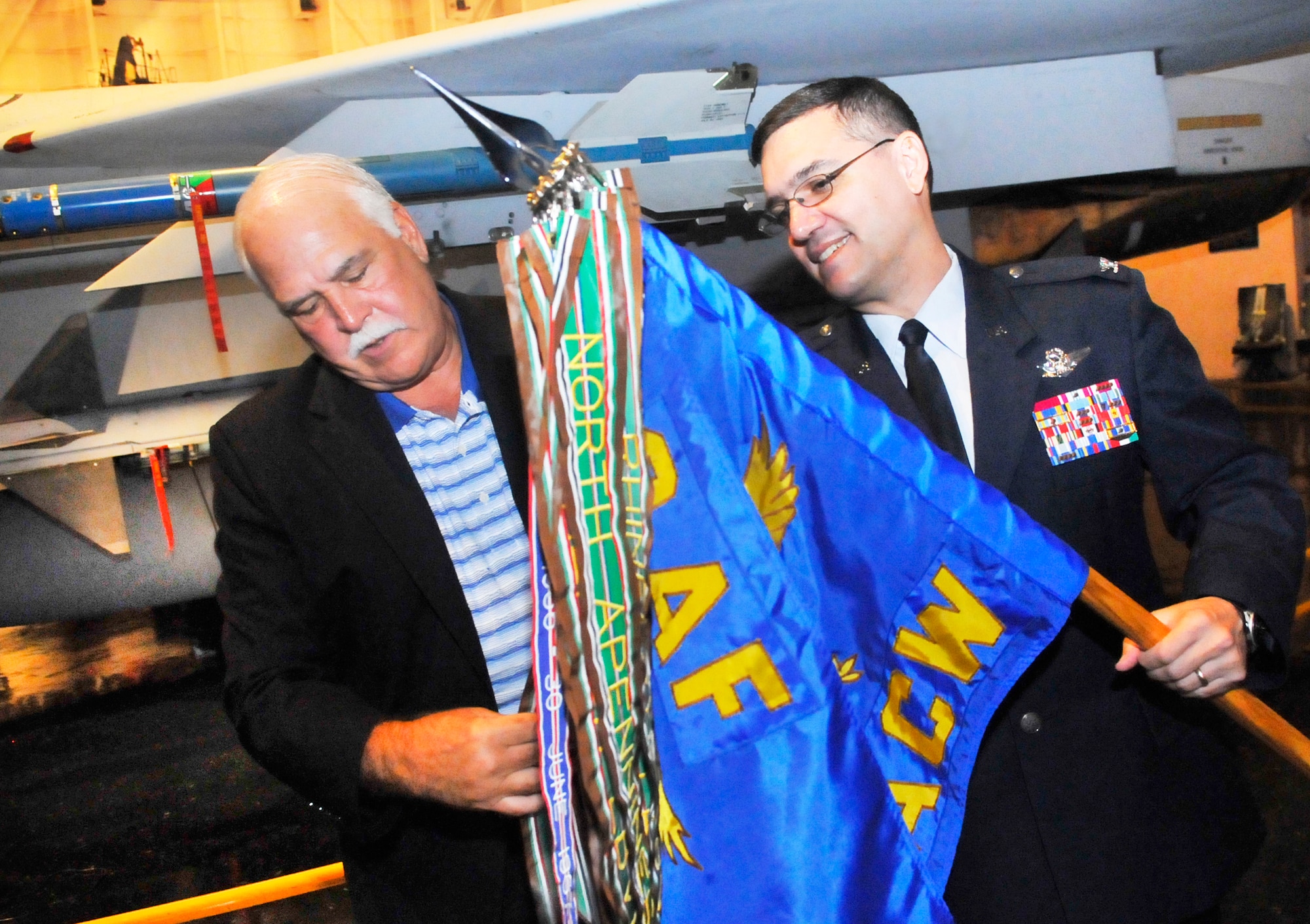 Col Dean Worley, right, 461st Air Control Wing commander, shows new honorary commander, Mike Dyer, Greater Macon Chamber of Commerce president, the 461st ACW guidon. A ceremony was held at the Museum of Aviation Friday to induct new commanders into the Honorary Commanders Program program for the  2012-2013 term . The program began in 2005 and was exclusive to the Warner Robins Air Logistics Center. However, with the current restructure, the program is now targeted to Team Robins to include mission partners. It is designed to encourage an exchange of ideas, experiences, and friendship between key members of the local civilian community and members of Team Robins.  The program is a method to foster a supportive relationship between the base and the community, increase military involvement in civic endeavors and organizations and make the members of the local community part of the Robins AFB family (U. S. Air Force photo/Sue Sapp)