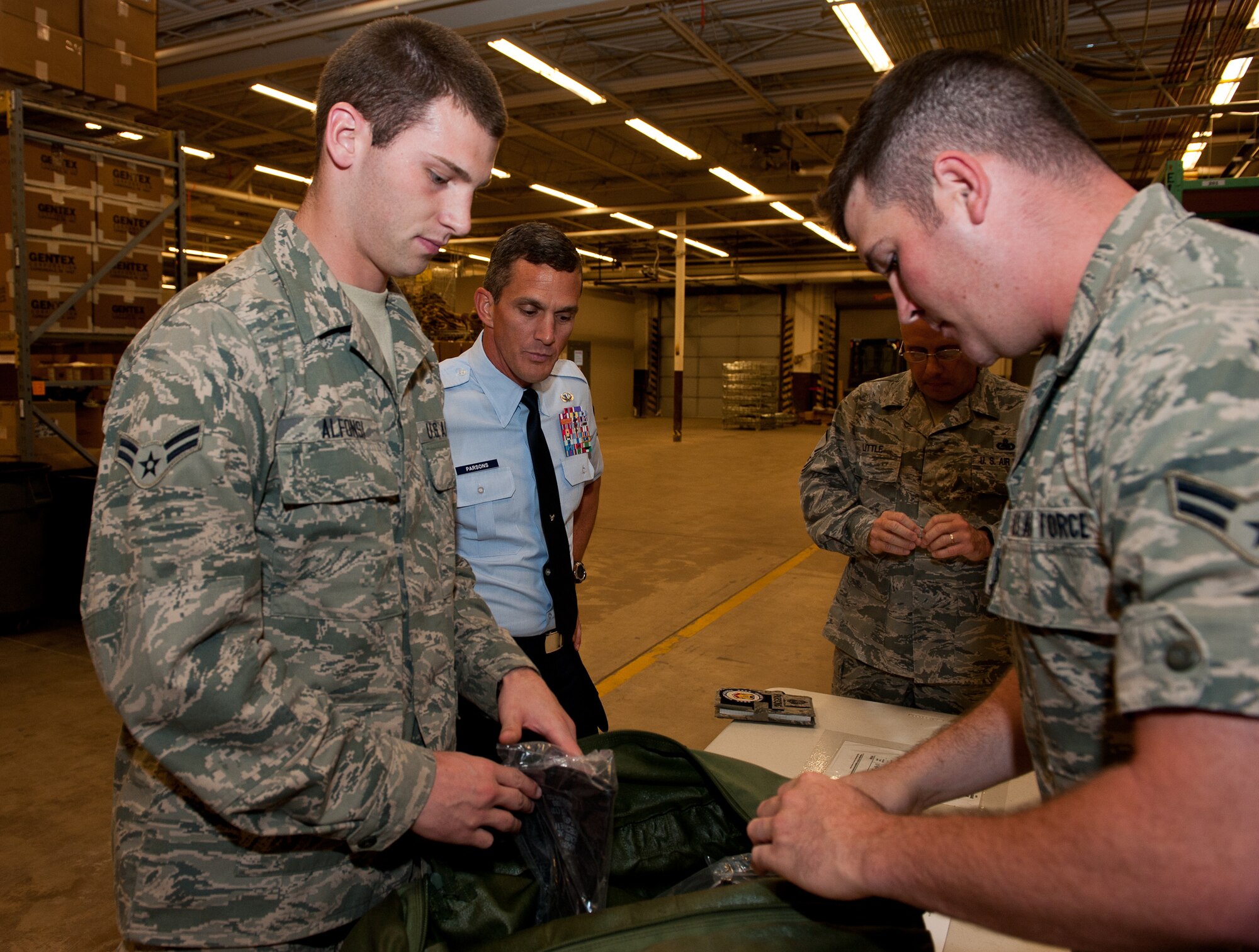 U.S. Air Force Chief Master Sgt. Richard Parsons, Air Combat Command command chief, watches as Airmen 1st Class Justin Alfonsi, Robert Martel, and Master Sgt. William Little, 28th Logistics Readiness Squadron individual protective equipment technicians, inspect an equipment bag in the Deployment Center on Ellsworth Air Force Base, S.D., Aug. 27, 2012. Parsons visited various organizations and facilities on Ellsworth to inform Airmen of current issues and concerns in ACC and the Air Force at large. (U.S. Air Force photo by Airman 1st Class Kate Thornton-Maurer/Released)