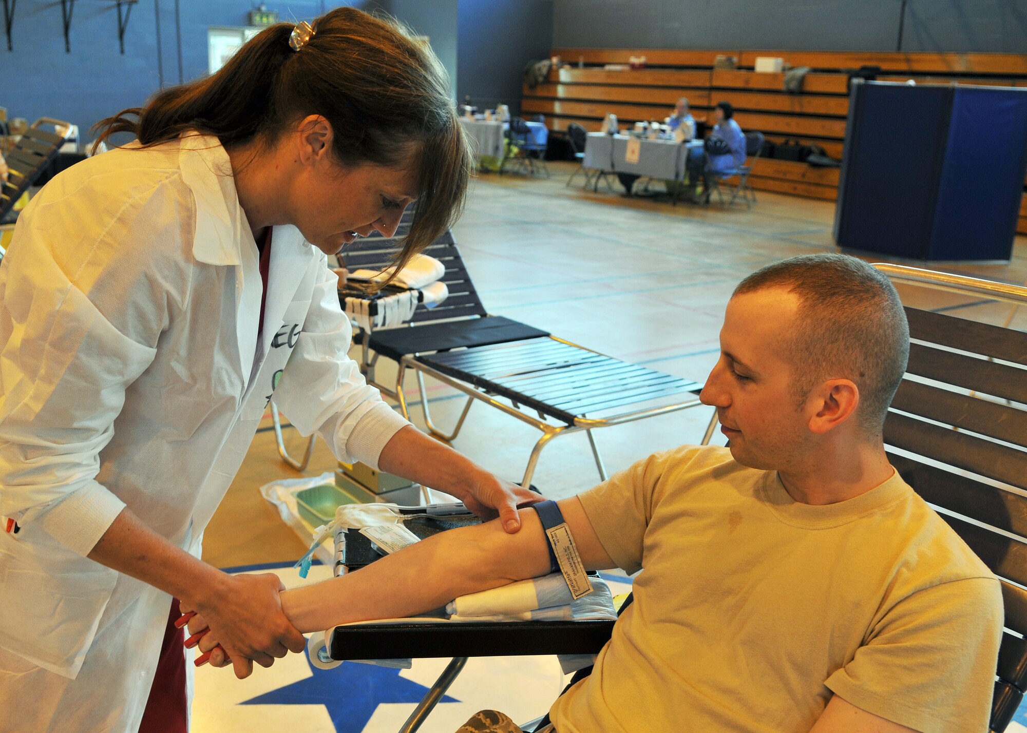 RAF MILDENHALL, England – Megan Krap, 86th Medical Squadron Armed Services Blood Program Blood Donation Center laboratory technician, Landstuhl, Germany, locates a vein on Staff Sgt. Jance Bishop, 100th Maintenance Squadron, during the ASBP Blood Drive, Sept. 5, 2012, at RAF Mildenhall, England.  The ASBP Blood Drive collected more than 100 units of blood from Team Mildenhall.  (U.S. Air Force photo/Staff Sgt. Tabitha M. Lee)