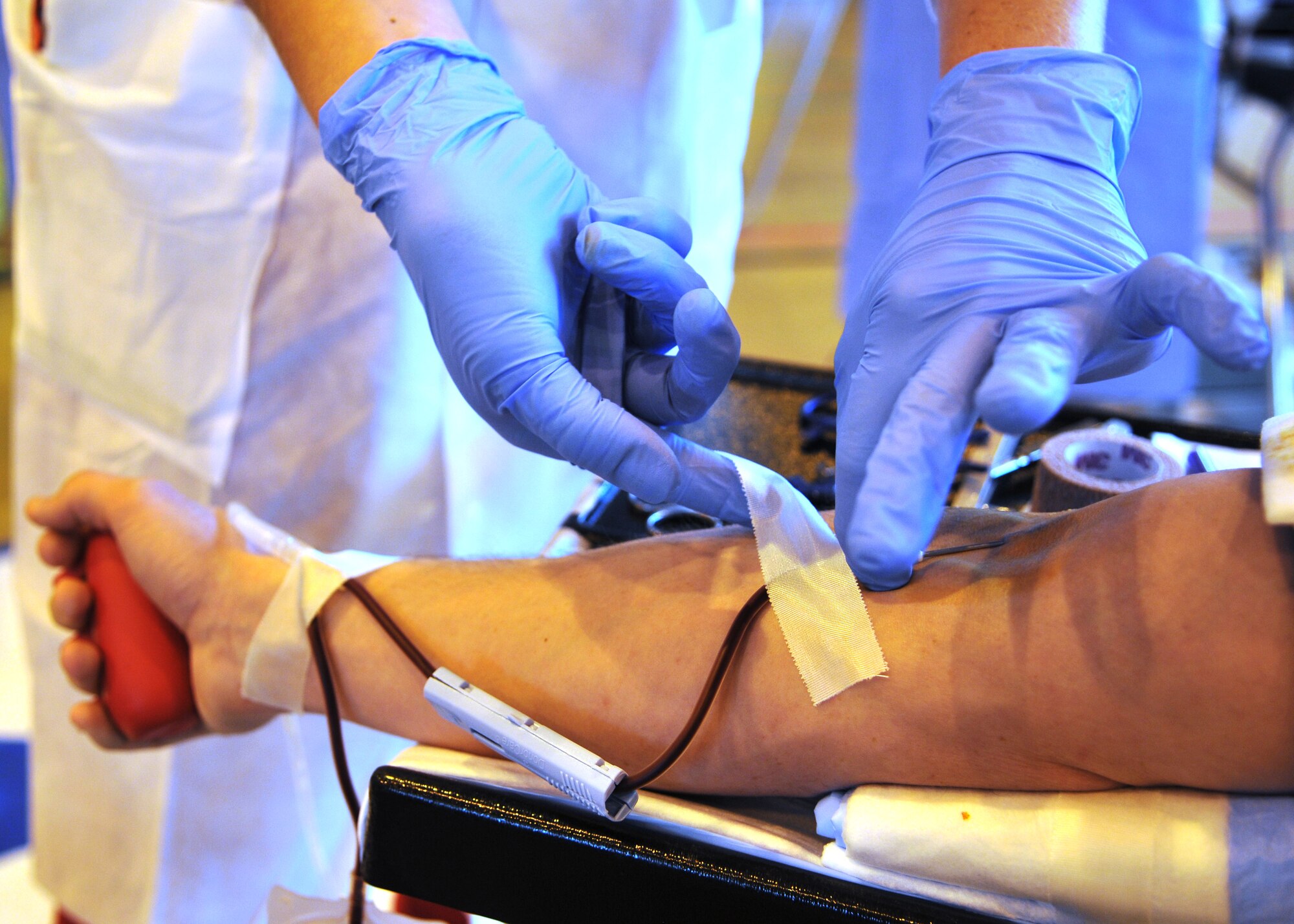 RAF MILDENHALL, England – Megan Krap, 86th Medical Squadron Armed Services Blood Program Blood Donation Center laboratory technician, Landstuhl, Germany, secures a tube with surgical tape to Staff Sgt. Jance Bishop, 100th Maintenance Squadron, during the ASBP Blood Drive, Sept. 5, 2012, at RAF Mildenhall, England.  The ASBP Blood Drive worked out of the North Side Fitness Center and collected more than 100 units of blood from Team Mildenhall.  (U.S. Air Force photo/Staff Sgt. Tabitha M. Lee)