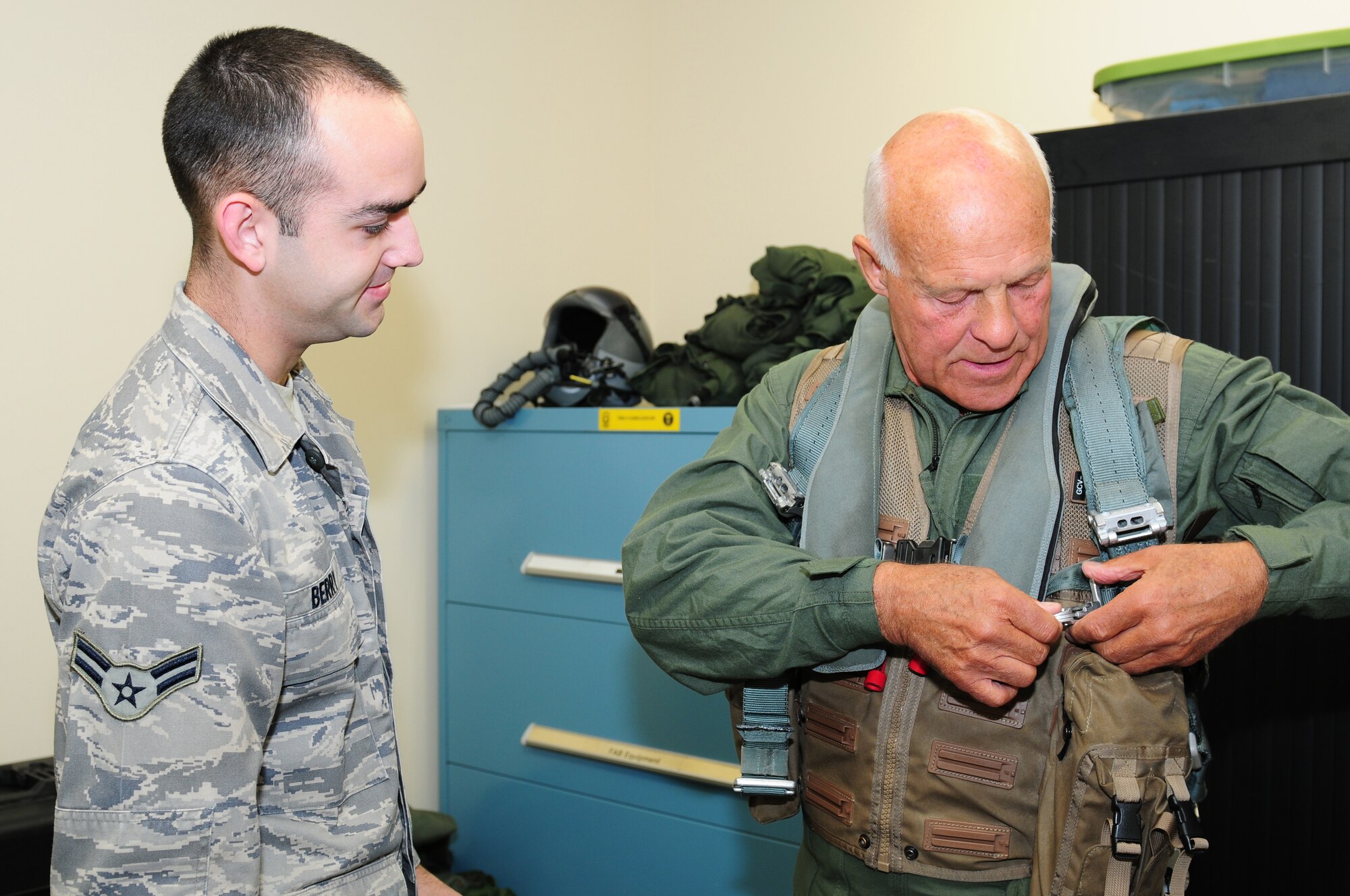 ROYAL AIR FORCE LAKENHEATH, England – Airman 1st Class Jeffrey Berry, 493rd Fighter Squadron air crew flight equipment, instructs John Cushing, 48th Fighter Wing honorary commander, on how to put on air crew equipment,  Sept. 6, 2012. Cushing received an incentive flight with the 493rd FS to receive a better understanding of how the 48th FW operates. Cushing is the chairman of the British-American Committee, which ensures the local relationship between American and British remains intact and encourages integration of the two communities. (U.S. Air Force photo by Airman 1st Class Cory D. Payne)