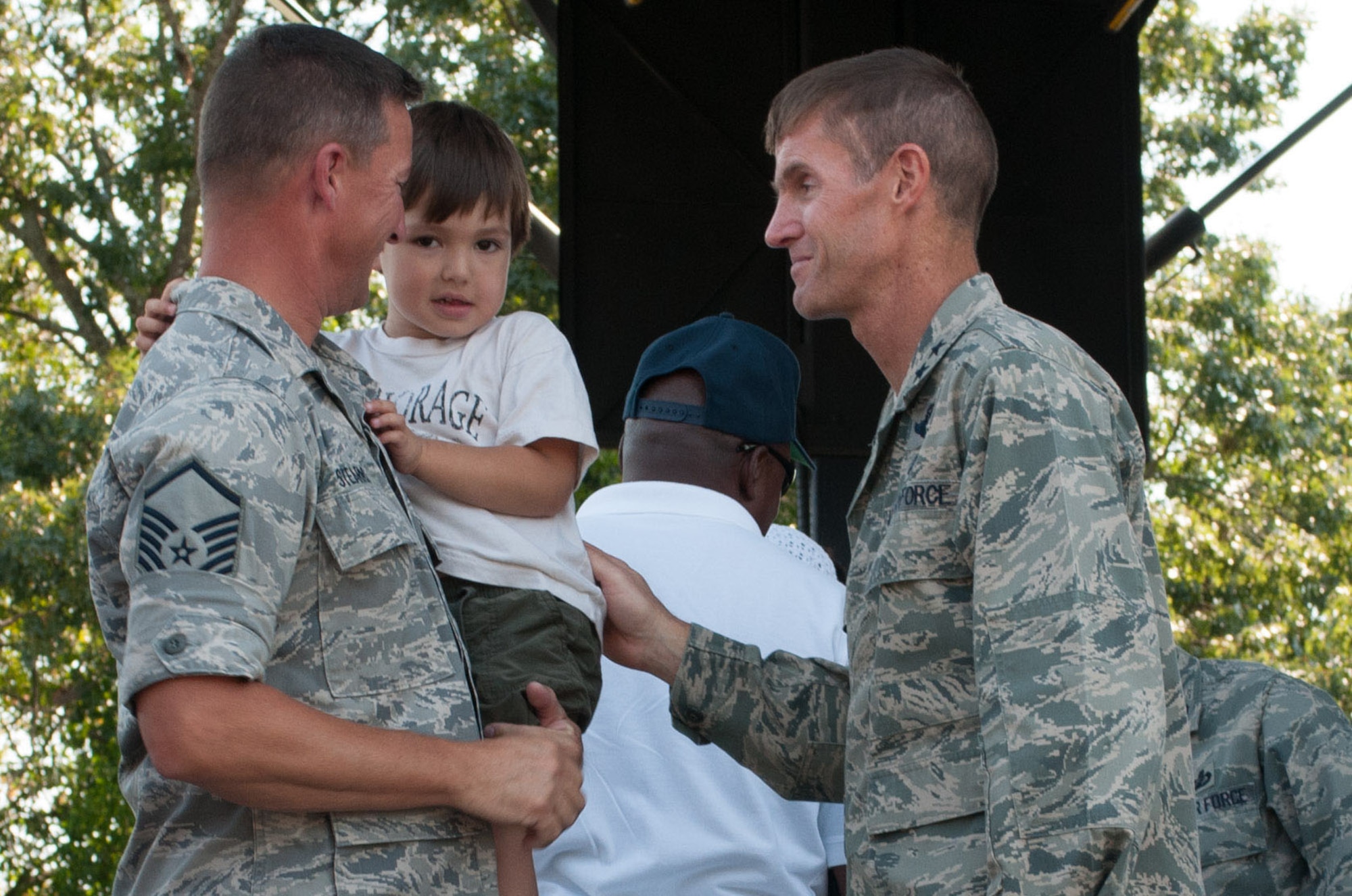 HANSCOM AIR FORCE BASE, Mass. – Maj. Gen. Craig Olson, program executive officer for Command, Control, Communications, Intelligence and Networks, greets returned deployer Master Sgt. Ted Stearns, Air Force Band of Liberty member, and his son, Gabriel, during Heroes Homecoming Aug. 30. (U.S. Air Force photo by Rick Berry)
