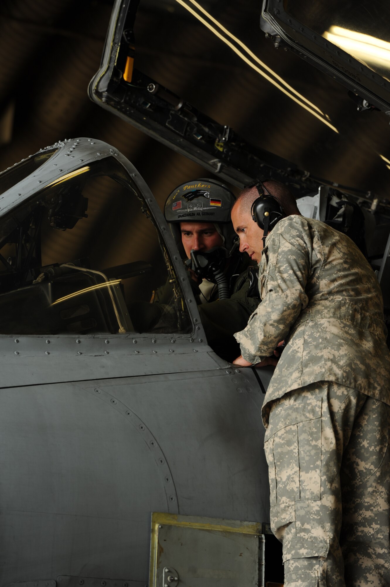 SPANGDAHLEM AIR BASE, Germany -- Capt. James Schmidt, 81st Fighter Squadron A-10 Thunderbolt II pilot, left, shows digital systems used to pursue targets to U.S. Army Chief Warrant Officer 3 Benjamin Bower, Joint Multinational Readiness Center (JMRC) UH-72 Lacota helicopter pilot, on the flightline here Sept. 5.  Members of JMRC visited the 81st Fighter Squadron to exchange close-air-support tactics, techniques and procedures. During their visit, they also flew in an A-10 simulator and viewed target information sent from ground forces to the A-10 pilots. The 81st FS shares and exchanges operating procedures with joint forces to ensure interoperability in future training exercises and contingency operations.   (U.S. Air Force photo by Senior Airman Natasha Stannard/Released)