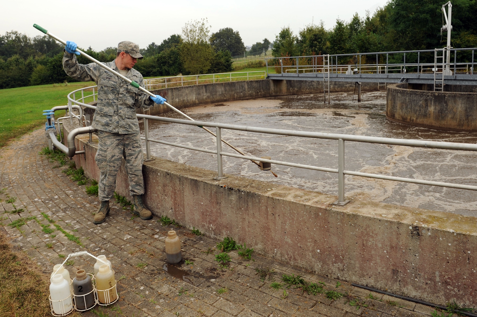 SPANGDAHLEM AIR BASE, Germany –Senior Airman David Spivey, 52nd Civil Engineer Squadron water and fuels system maintenance technician, takes a sample of wastewater from a tank during a daily sample inspection at the wastewater treatment facility here Sept. 5. Samples are taken daily from every stage of the treatment process to ensure they meet German environmental standards. The facility processes wastewater from the base to remove any hazardous chemicals it may contain before it is released back into the environment. (U.S. Air Force photo by Senior Airman Christopher Toon/Released)