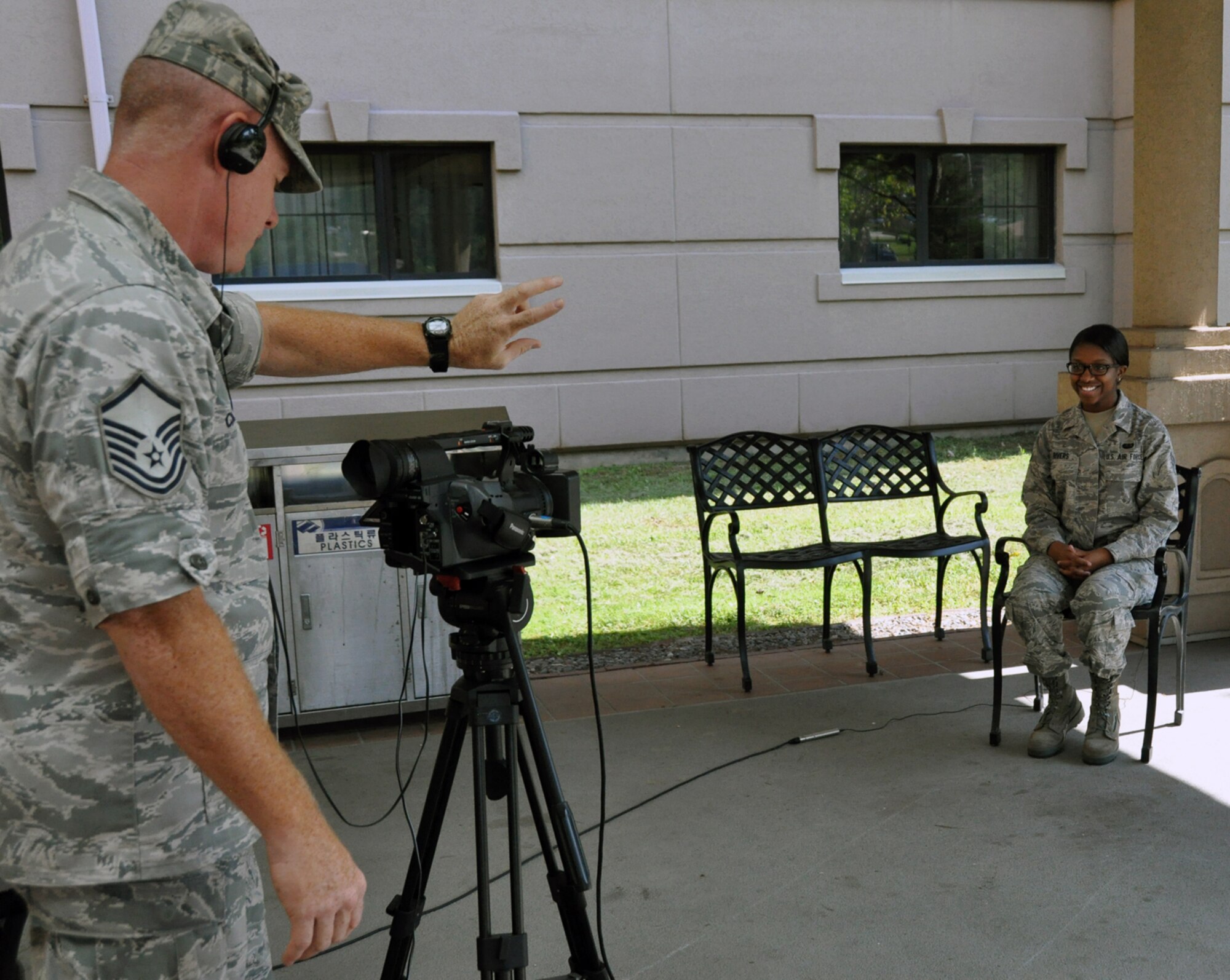 Master Sgt. John Cronin, a broadcaster from the Joint Hometown News Service at Fort George G. Meade, Md., counts down in preparation for Senior Airman Shiantee Rivers, 51st Force Support Squadron, to record her holiday greeting at Osan Air Base, Republic of Korea, Sept. 6, 2012. The greetings will air in Rivers’ hometown between Thanksgiving and New Years. (U.S. Air Force photo/Senior Airman Michael Battles)