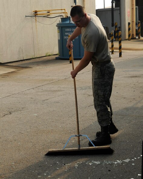 A member  of the 8th Logistics Readiness Squadron cleans up glass from a shattered window at Kunsan Air Base, Republic of Korea, Aug. 29, 2012. The base was quick to fix damages caused by Typhoon Bolaven and maintained full operational capabilities. (U.S. Air Force photo/Senior Airman Marcus Morris)