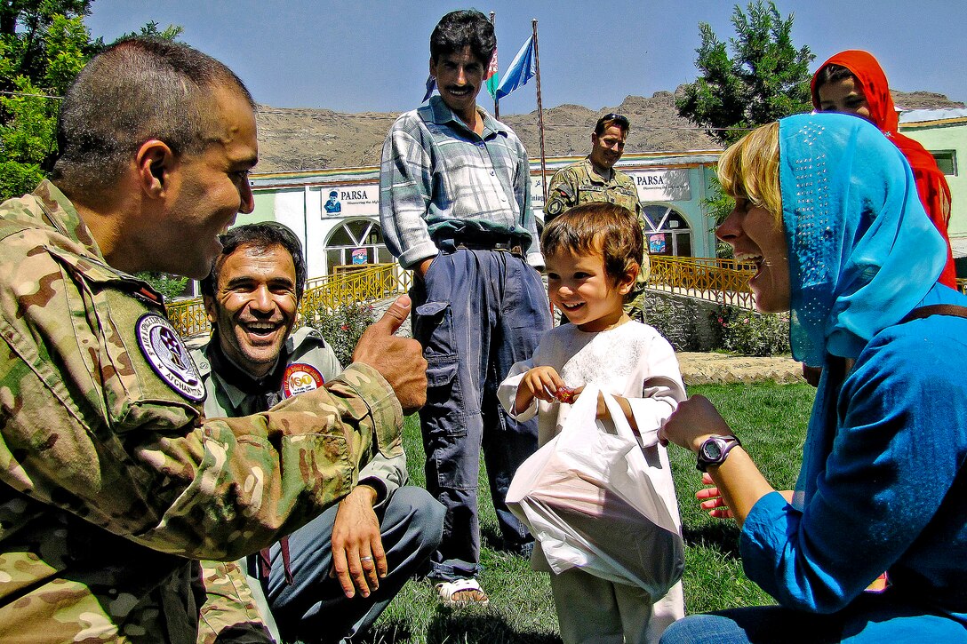 International Security Assistance Force members play with an Afghan child at the Physiotherapy and Rehabilitation Support for Afghanistan Orphanage in Kabul, Afghanistan, Aug. 31, 2012. The service members were on hand to pass out school supplies and candy to children at the orphanage.
