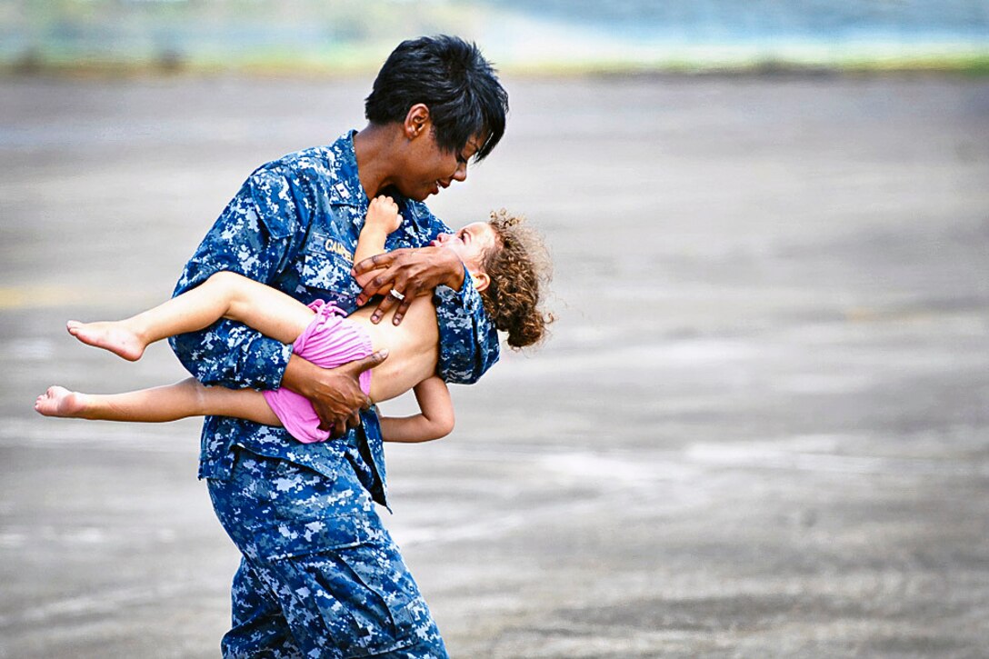 Navy Lt. Lori Campbell carries a young girl to safety on Naval Air Station Joint Reserve Base New Orleans, La., Sept. 1, 2012. The girl was medically evacuated from Port Sulphur, La., by members of the Louisiana Army National Guard's 2-135th General Support Aviation Battalion.