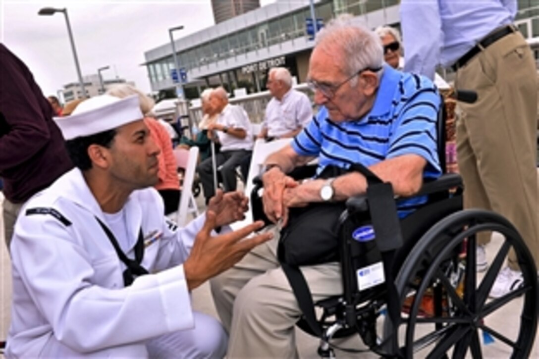 Navy Petty Officer 2nd Class Alfredo Brugal speaks with George Pellek, a Navy veteran from WWII, during the Navy's commemoration of the bicentennial of the War of 1812 in Detroit, Sept. 5, 2012. The event coincides with Detroit Navy Week, one of 15 signature events planned across America in 2012.