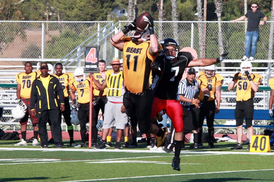 1st Marine Logistics Group Beast's wide receiver Chris Warder catches a pass from quarterback Matthew Petree for a first down against Marine Air Support Squadron 3 Blacklist at Marine Corps Base Camp Pendleton, Calif., Aug. 20.  The Beast defeated Blacklist 48-0, and improved their record to 3-0.