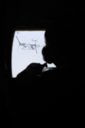 Lance Cpl. Jamie Nadeau, a crew master with Detachment A, Marine Aerial Refueler Transport Squadron 352, keeps an eye on a MV-22 Osprey out of one of the KC-130J?s windows during an escort mission from Helmand province, Afghanistan, to the USS Iwo Jima in the Arabian Sea, Sept. 6, 2012. Nadeau ensured the Ospreys maintained enough separation and had no obvious mechanical issues.