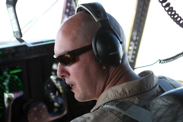 Capt. G. O. Ryberg, a KC-130J pilot with Detachment A, Marine Aerial Refueler Transport Squadron 352, looks out a window in the cockpit for a visual sign of four MV-22 Ospreys, Sept. 6, 2012. The KC-130J escorted the Ospreys from Helmand province, Afghanistan, to the USS Iwo Jima in the Arabian Sea.