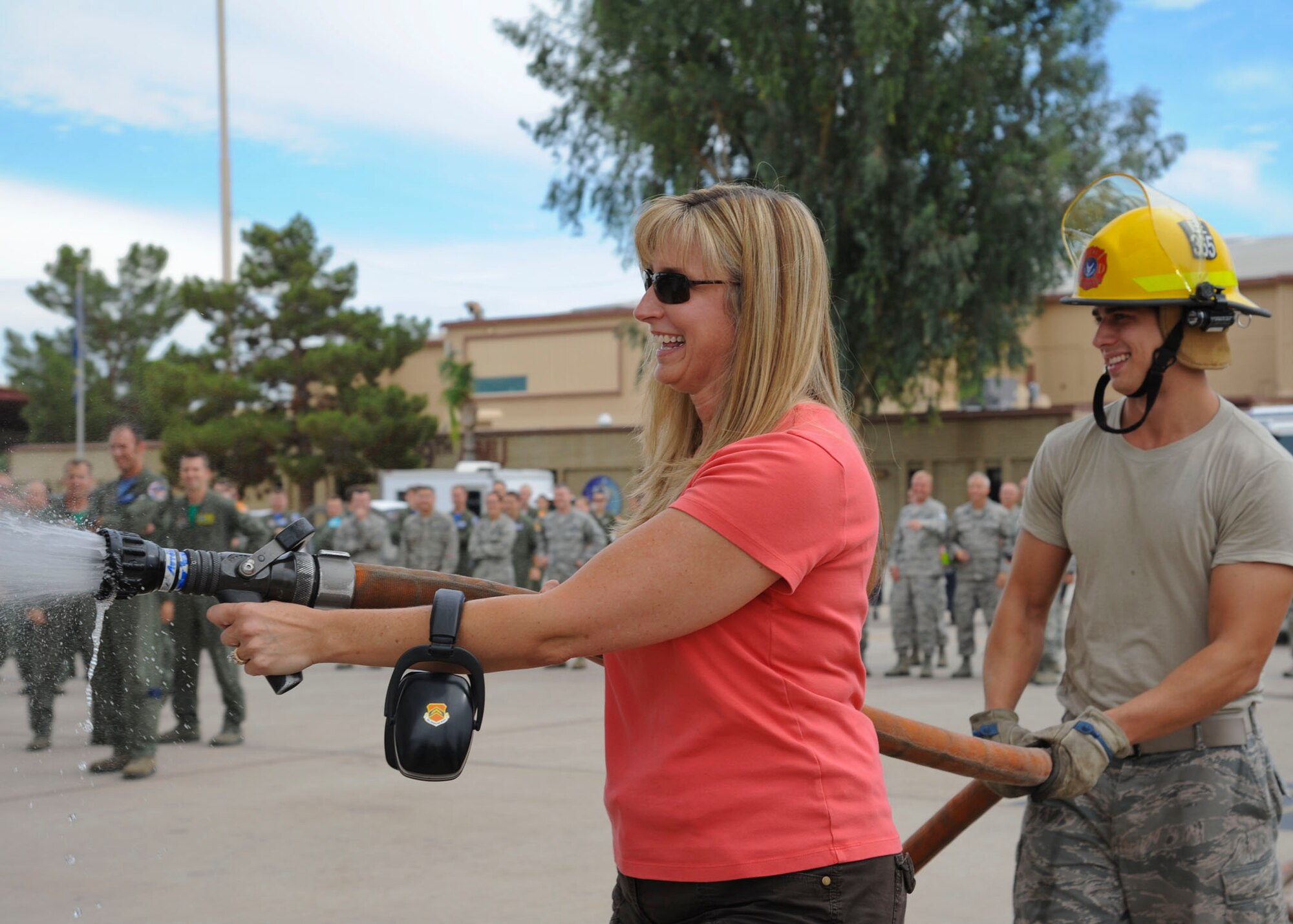 Heather Harris, wife of Brig. Gen. JD Harris, 56th Fighter Wing commander, sprays down her husband upon completion of his final flight at Luke Air Force Base Sep. 7. (U.S. Air Force photo by Staff Sgt. Darlene Seltmann)