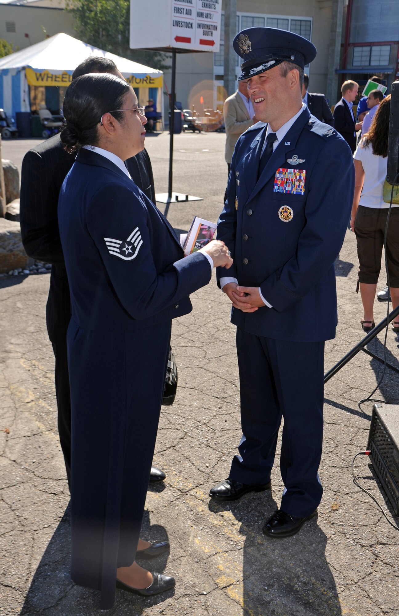 Col. Brian Newberry, 92nd Air Refueling Wing commander, talks with Staff Sgt. Abigail Foster, 92nd Maintenance Squadron non-destructive inspection journeyman, thanking her for her service and performance of the National Anthem at the opening ceremonies of the 61st Annual Spokane County Interstate Fair in Spokane, Wash., Sept. 7, 2012. Foster is scheduled to sing at several other events during the two-week long festival. (U.S. Air Force photo by Senior Airman Benjamin Stratton)