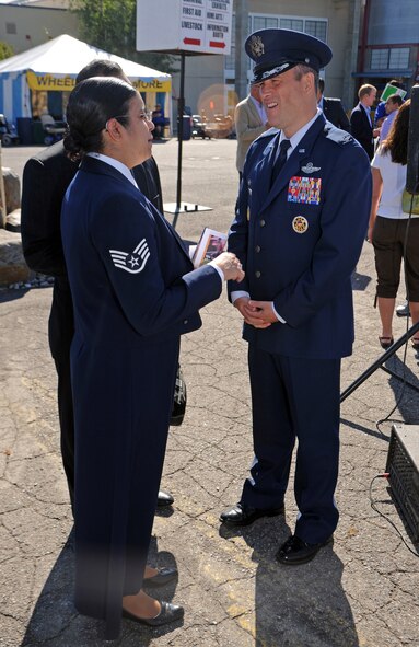 Col. Brian Newberry, 92nd Air Refueling Wing commander, talks with Staff Sgt. Abigail Foster, 92nd Maintenance Squadron non-destructive inspection journeyman, thanking her for her service and performance of the National Anthem at the opening ceremonies of the 61st Annual Spokane County Interstate Fair in Spokane, Wash., Sept. 7, 2012. Foster is scheduled to sing at several other events during the two-week long festival. (U.S. Air Force photo by Senior Airman Benjamin Stratton)