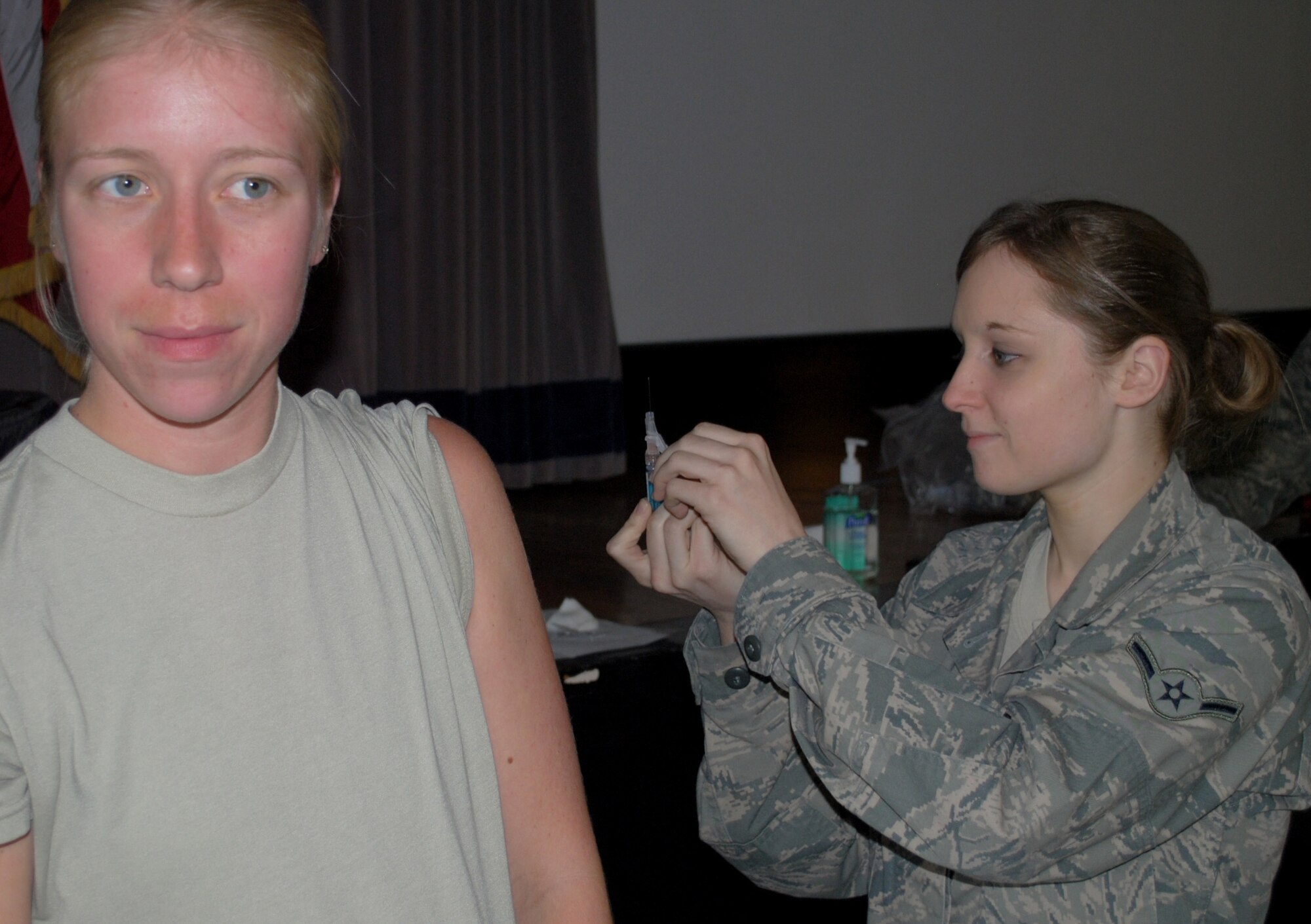 Airman Chelsea Leindecker, 319th Medical Operations Squadron aerospace medical technician, prepares an influenza vaccine injection for Tech. Sgt. Elizabeth Wek on Sept. 7, 2012 at Grand Forks Air Force Base, N.D. Four flu vaccination sessions are part of the 319th Medical Group’s implementation of the Air Force 2012-2013 Influenza Immunization Program, which sets a vaccination coverage goal of at least 90 percent for all service members by Dec. 17, 2012. (U.S. Air Force photo/Senior Airman Luis Loza Gutierrez)