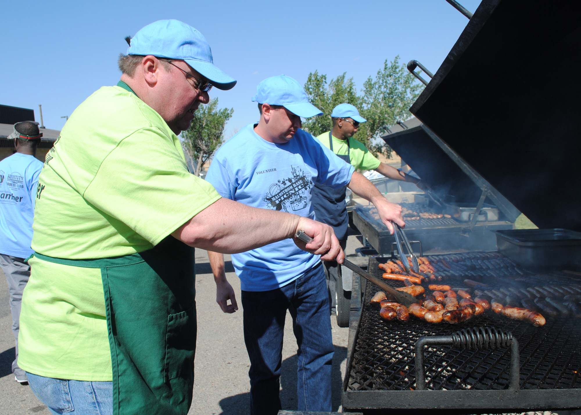 Steve Grooms, Military Affairs Committee chairman, volunteered to cook hotdogs, hamburgers and bratwurst at the annual military appreciation picnic at Sun Plaza Park on Aug. 24. Members of the MAC volunteered alongside Team Malmstrom members to cook food, serve food and operate stations for children’s activities. (U.S. Air Force photo/Airman 1st Class Katrina Heikkinen)
