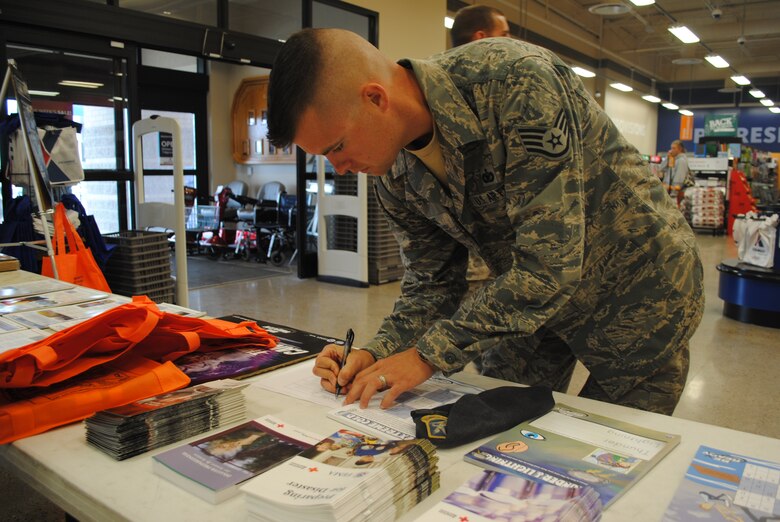 Staff Sgt. Zack Osborne, 341st Security Forces Squadron response force leader, signs up for a chance to win an adult starter kit, which includes flash lights, protein bars, blankets and a first aid kit. (U.S. Air Force photo/Airman 1st Class Katrina Heikkinen)