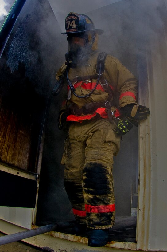 11th Civil Engineer Squadron firefighter exits the flashover identification trainer Aug. 28, 2012. A flashover is the near-simultaneous ignition of most of the directly-exposed combustible material in an enclosed area. Flashover identification training lets firefighters learn the life saving skill of recognizing the indicators of flashover. (U.S. Air Force Photo/enior Airman Perry Aston)