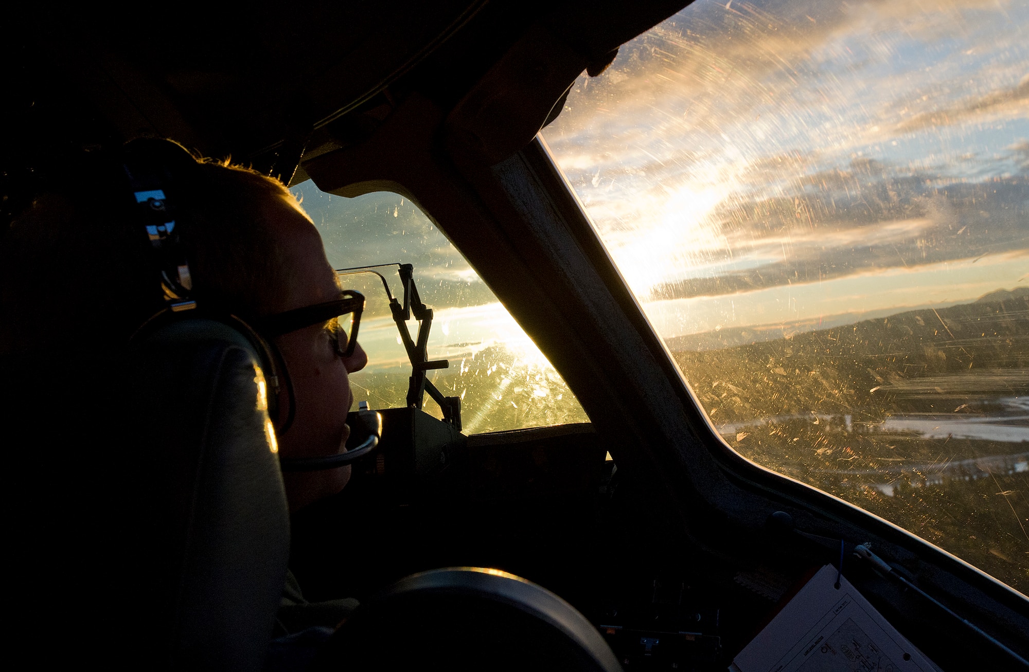 Air Force Captain Zach Deshetler, 517th Airlift Squadron C-17 Globemaster III cargo plane pilots, looks out over the Alaska terrain during flight training over Joint Base Elmendorf-Richardson, Aug. 23, 2012. C-17 aircraft from JBER support a variety of missions around the world, many of which include dropping U.S. Army paratroopers. (U.S. Air Force photo by Staff Sgt. Zachary Wolf)