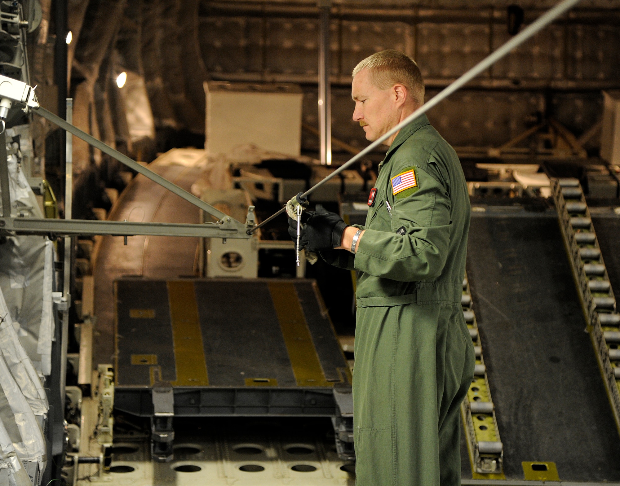 Tech. Sgt. Terry Langston, 517th Airlift Squadron loadmaster, wipes down a cable on a C-17 Globemaster III cargo plane on Joint Base Elmendorf-Richardson, Aug. 23, 2012. C-17 aircraft from JBER support a variety of missions around the world, many of which include dropping U.S. Army paratroopers. (U.S. Air Force photo by Staff Sgt. Zachary Wolf)