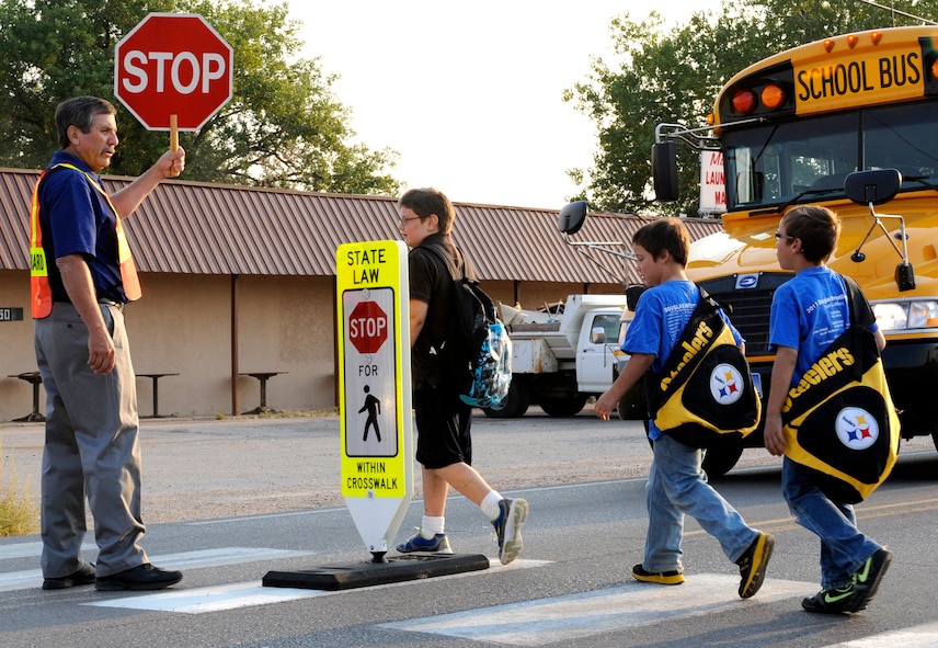Rick Hatfield, Vandenberg Elementary School Title 1 Math and Reading teacher and volunteer crossing guard, stops traffic while students walk across Liberty Boulevard in Box Elder, S.D., Sept. 6, 2012. Douglas School District officials have posted crossing guards at different intersections around their schools due to the increase in vehicle and pedestrian traffic as a result of the change in bussing availability and housing accommodations for Ellsworth Air Force Base residents. (U.S. Air Force photo by Airman Ashley J. Woolridge/Released)