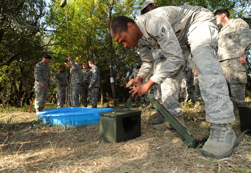 MINOT AIR FORCE BASE, N.D. – Airman 1st Class Quincy Brooks, 91st Missile Security Forces Squadron response force leader, secures a battery with a latch as part of an obstacle which required the movement of individuals and items across an area without touching the ground. During this Leadership Reaction Course, the lowest ranking Airmen were put in charge of NCO’s and Airmen and were the only ones allowed to speak and direct commands to accomplish the obstacles.  (U.S. Air Force photo/Senior Airman Jose L. Hernandez)
