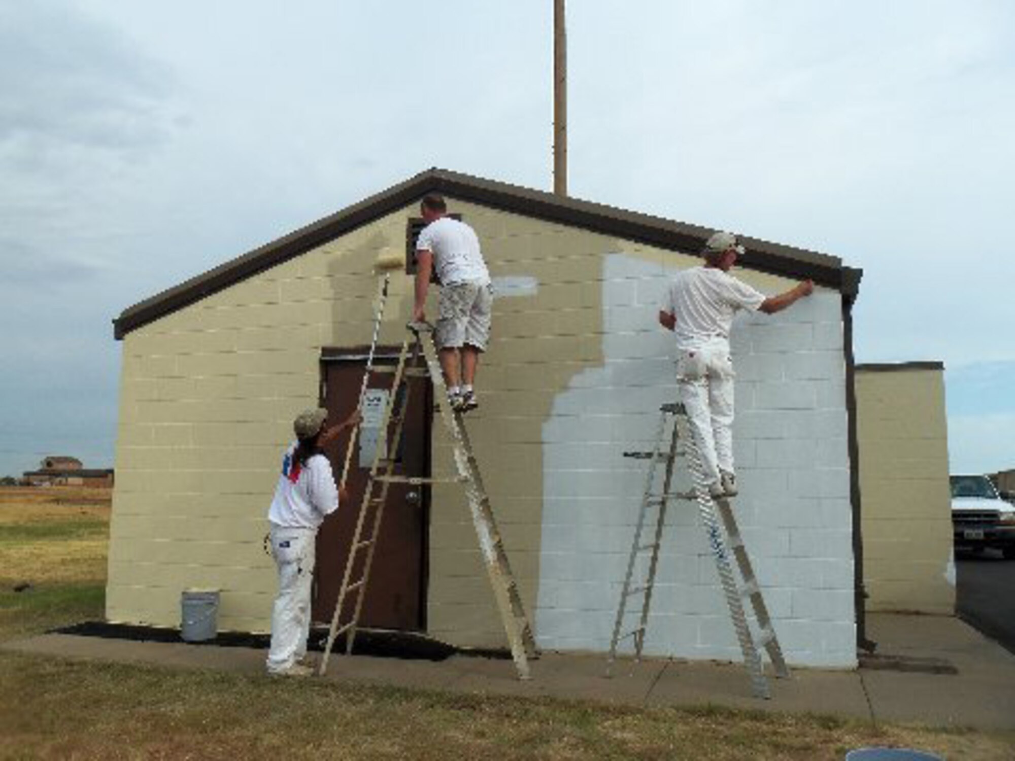 Contractors paint Building 2542 with Insuladd on Sheppard Air Force in August, 2012.  Insuladd, which is a paint additive, has insulating qualities which reduce heat transfer by approximately 30 percent. (U.S. Air Force courtesy photo)