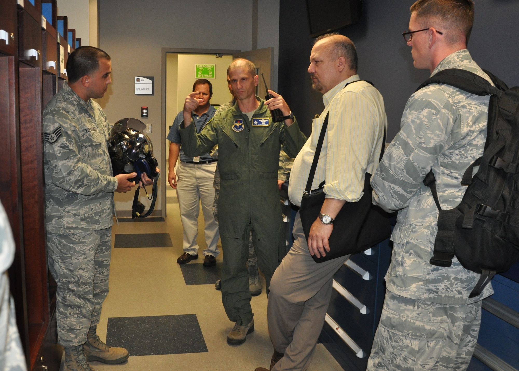 Lt. Col. Randal Efferson, center, and Staff Sgt. Lemuel Velazquez, left, explain to evaluators how the F-35 Lightning II helmet is custom fit to the pilot’s head. Velazquez said the key elements of the helmet are fully incorporated so the pilot can more effectively focus on his tasks and avoid cockpit distractions. Efferson is the deputy operations group commander, 33rd Fighter Wing and Velazquez is an aircrew flight technician, 33rd Operations Support Squadron. (U.S. Air Force photo/Major Karen Roganov)