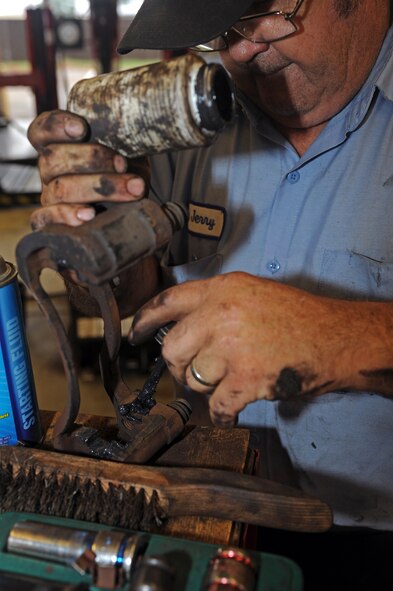 Jerry Cazeault, 4th Force Support Squadron mechanic, applies grease to a caliper bracket at the Auto Hobby Shop on Seymour Johnson Air Force Base, N.C., Sept. 6, 2012. Having greased caliper brackets allows for easier braking. (U.S. Air Force photo/Airman 1st Class John Nieves Camacho/Released)