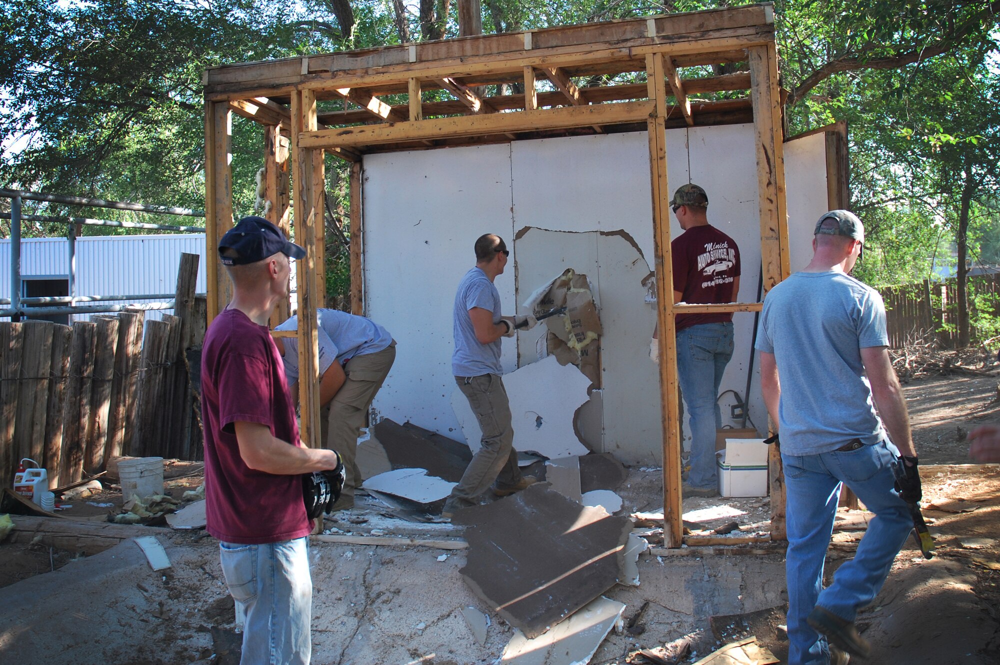 Members from the 27th Special Operations Civil Engineer Squadron tear down the existing black swan exhibit to begin replacing outer panels at The Hillcrest Zoo, Clovis, N.M., Aug. 31, 2012. Cannon's 5/6ers organized and coordinated the volunteer beautification project between base personnel and the zoo. (Courtesy photo)  