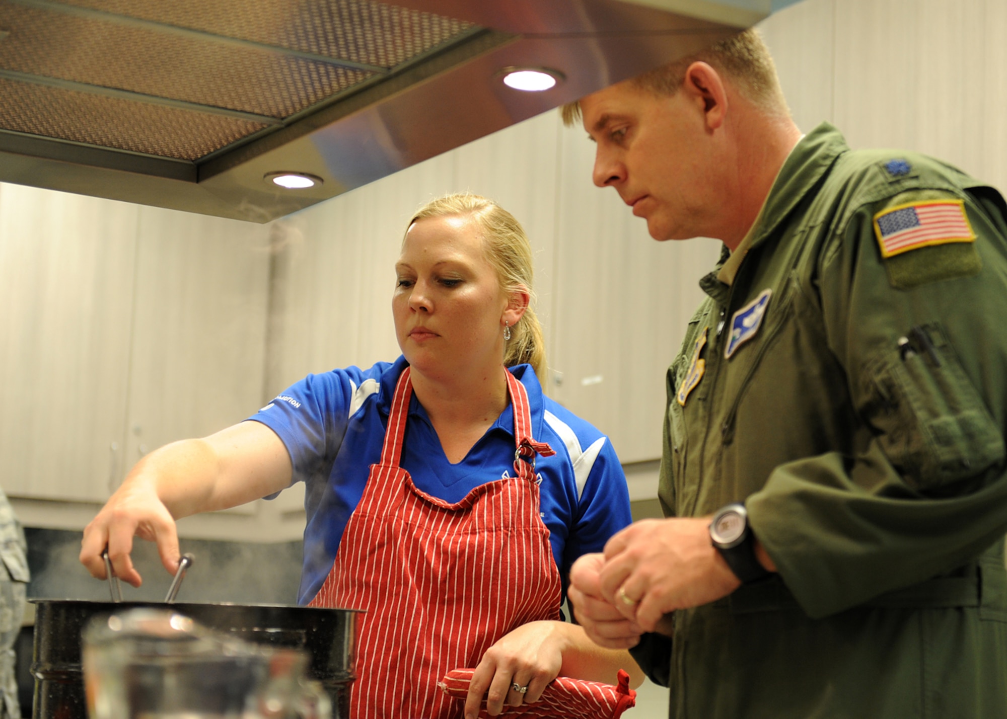 Alyson Kresser, 92nd Aerospace Medicine Squadron Health and Wellness Center registered dietitian, shows Lt. Col. James O'Connell, 92nd Air Refueling Wing inspector general, how to seal and preserve a jar of peaches at Fairchild Air Force Base, Wash., Aug. 22, 2012. The HAWC hosts regular cooking classes to demonstrate how to use fresh, seasonal foods to make healthy meals and snacks. (U.S. Air Force photo by Staff Sgt. Michael Means)