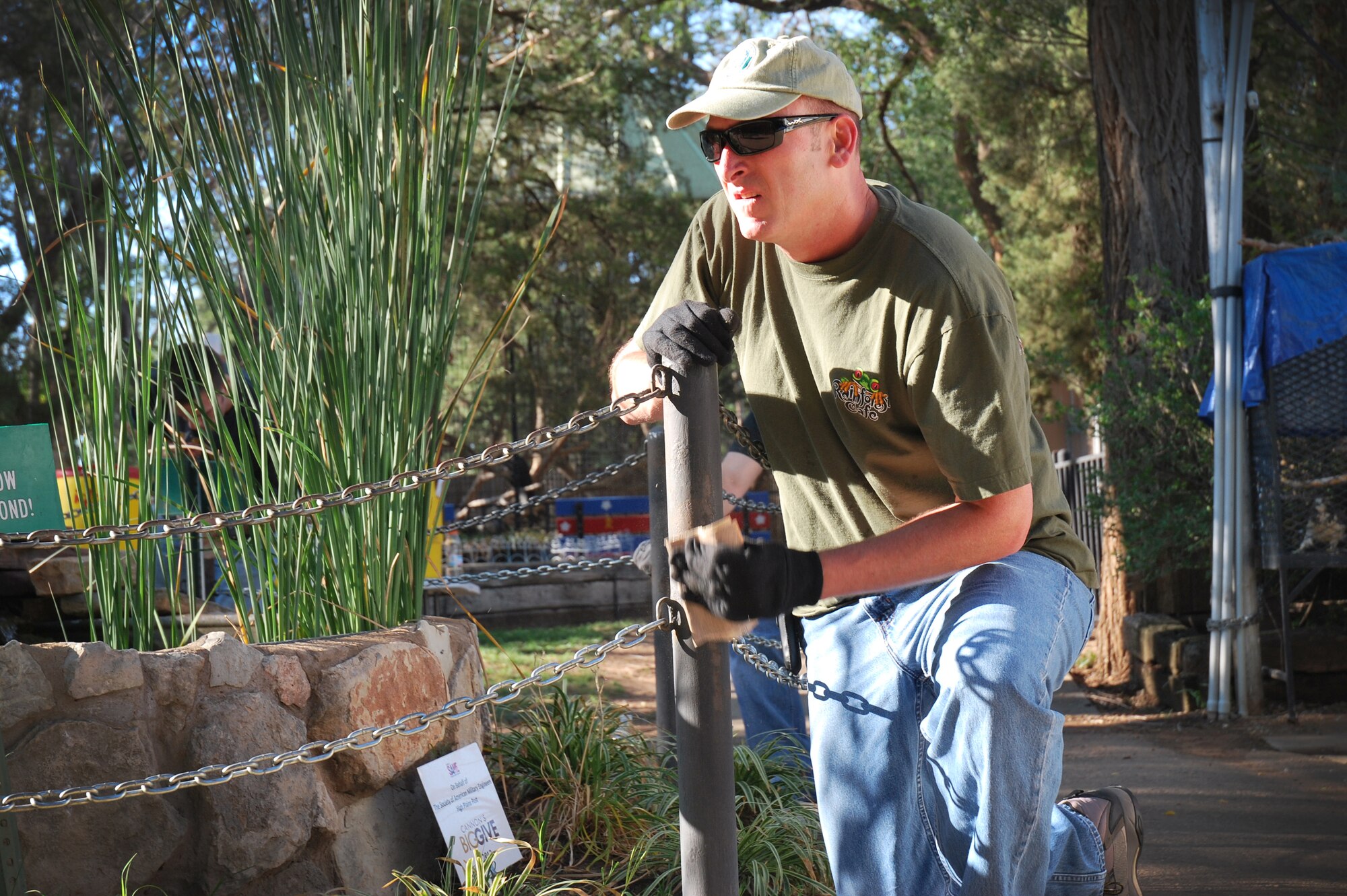 U.S. Air Force Chief Master Sgt. Paul Henderson, 27th Special Operations Wing command chief, sands down a pole to prepare it for painting at The Hillcrest Zoo, Clovis, N.M., Aug. 31, 2012. Cannon's 5/6ers organized and coordinated the volunteer beautification project between base personnel and the zoo.  (Courtesy photo)    