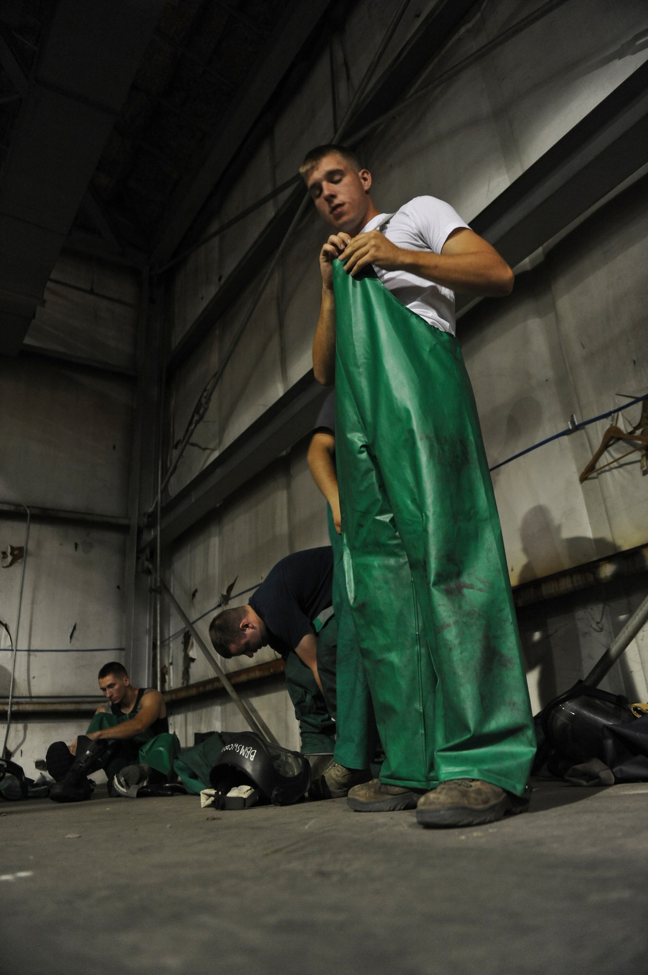 Airmen from the 2nd Maintenance Squadron don proper protective equipment for a B-52H Stratofortress wash in the corrosion hangar on Barksdale Air Force Base, La., Aug. 22. The Airmen donned the PPE to protect them from harmful skin irritants. The PPE required for the wash is two pairs of gloves, a pair of goggles, a face shield, rain boots and a water resistant jacket and pants. (U.S. Air Force photo/Airman 1st Class Micaiah Anthony)(RELEASED)