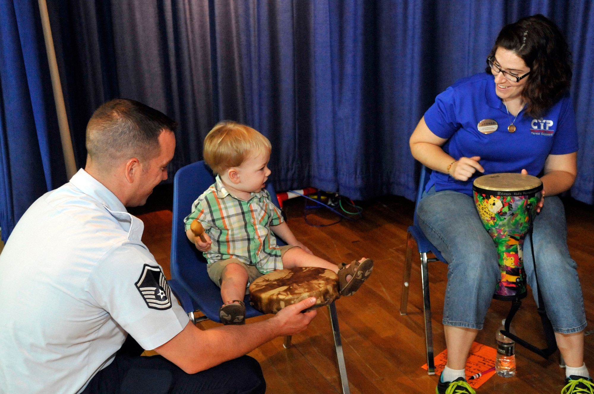 Matthew Ottenwess, 2, and father Master Sgt. Chris Ottenwess, 305th Operations Support Squadron boom operator, play the drums along with Tina Fernandes, 87th Air Base Wing Child and Youth Program, program assistant, Aug. 27 at the Joint Base McGuire-Dix-Lakehurst Exceptional Family Member Fun Fest. (U.S. Air Force photo by Wayne Russell/Released)