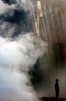 A solitary firefighter stands amidst the ruble and smoke in New York City, Sept. 14, 2001. Days after the Sept. 11 terrorist attack, fires still burn at the site of the World Trade Center. (Courtesy photo)