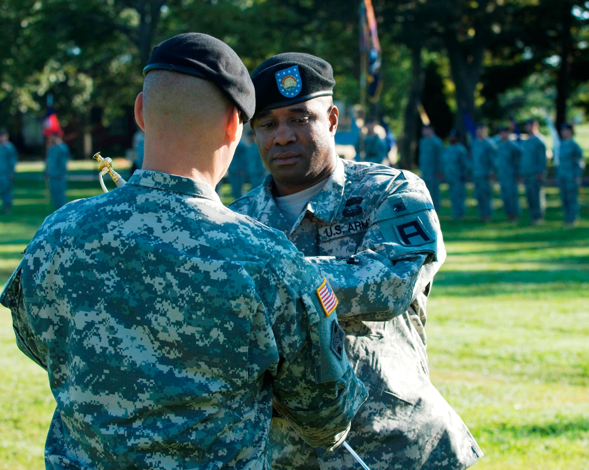Command Sgt. Maj. Calvin Coler accepts the noncommissioned officers sword from Col. Craig A. Osborne, during a traditional change of responsibility ceremony Aug. 30 at Sharp Field here. (U.S. Army photo by Master Sgt. Patrick Compton/Released) 